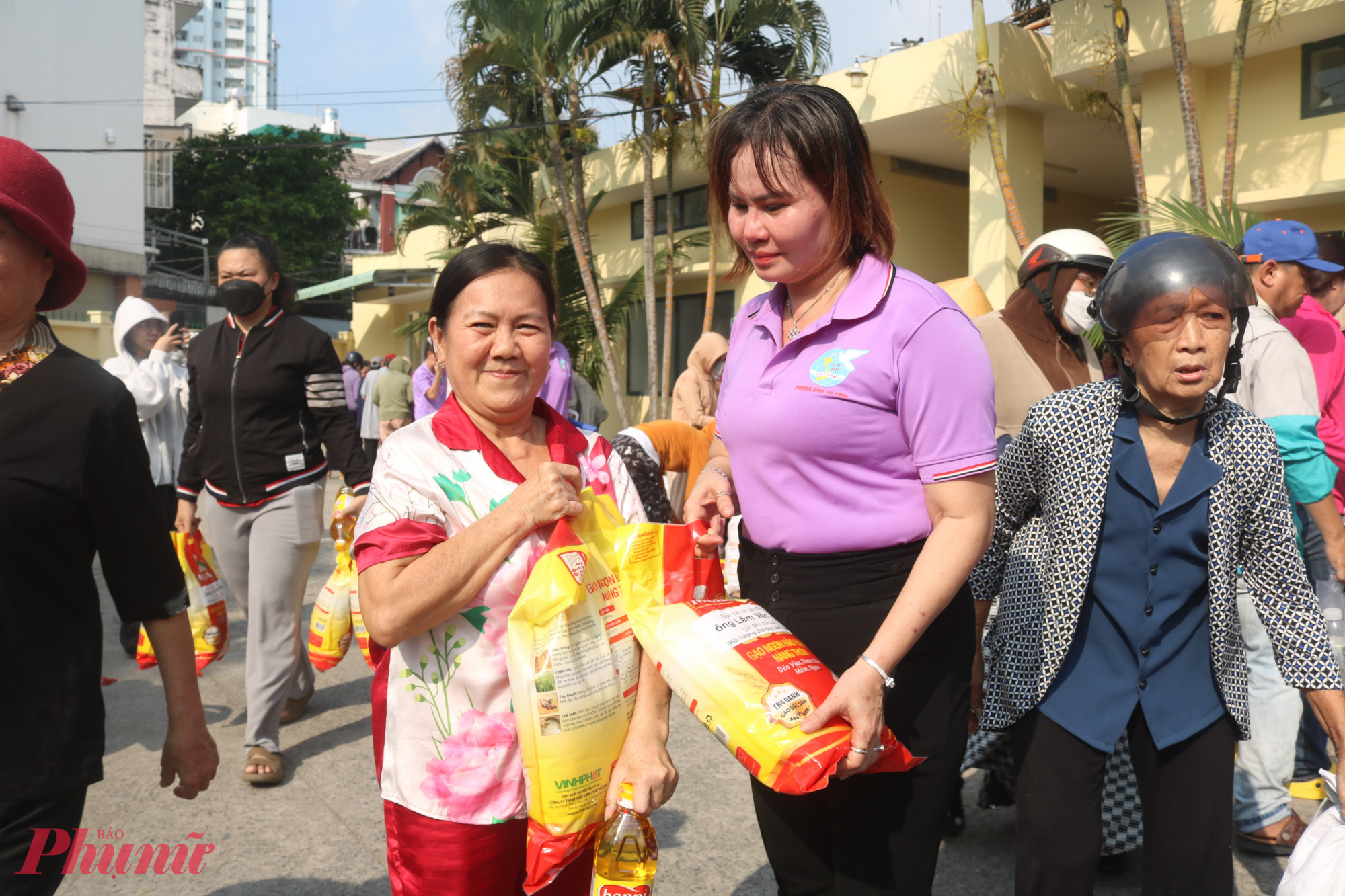 Cán bộ Hội Phụ nữ phường Bình Trị Đông trao những túi gạo đến tay các dì, các chị - Ảnh: Mẫn Nhi