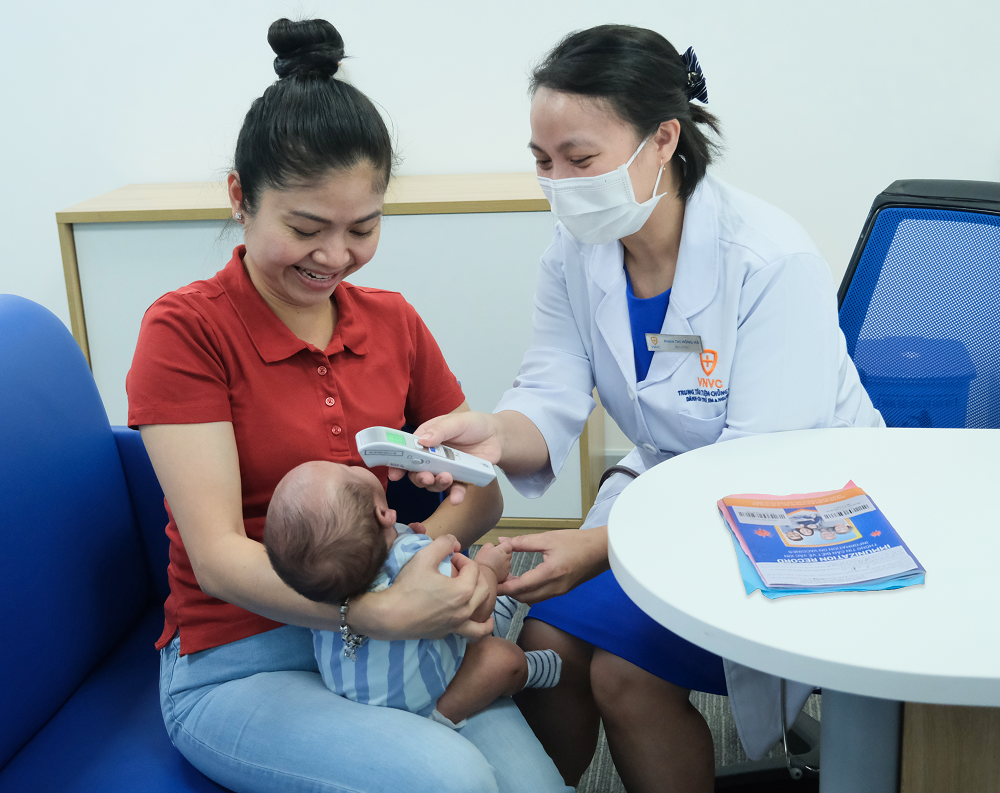 Chị Vạn Chí Linh cho con trai tiêm kháng thể đơn dòng phòng RSV tại VNVC Lê Đại Hành (TPHCM) sáng ngày 23/12 - Ảnh: Diễm Chinh