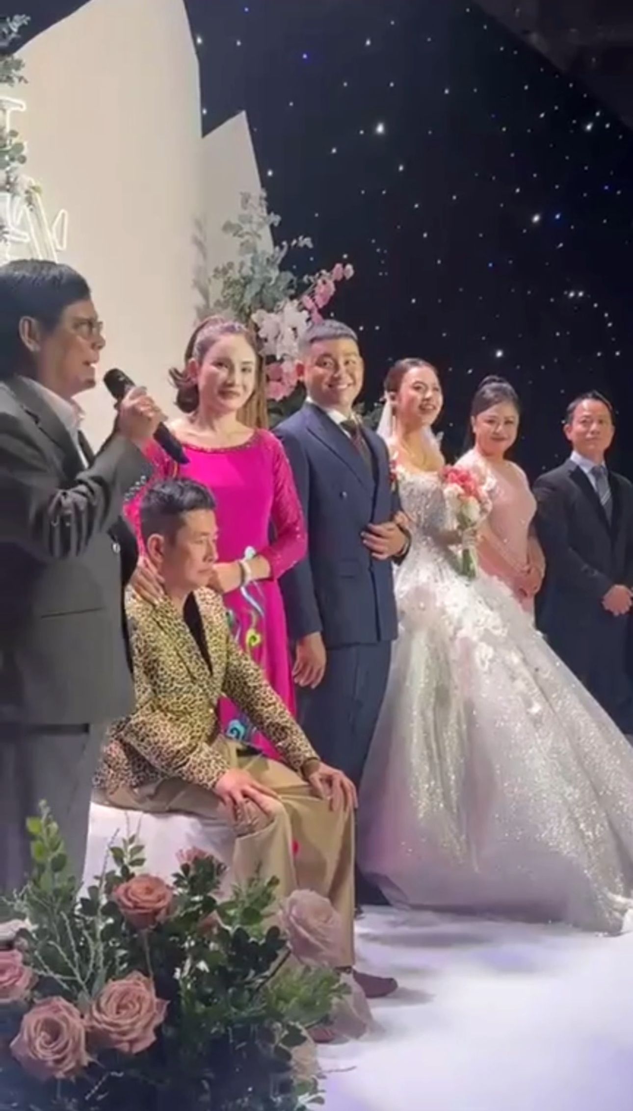 Nghệ sĩ Tấn Beo được dìu lên sân khấu, ngồi ghế trong hôn lễ của con trai Tấn Lộc