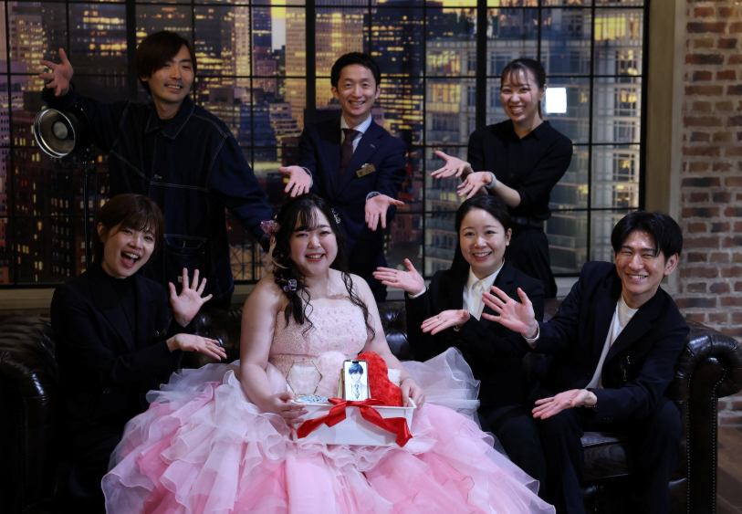 Yurina Noguchi, 32 tuổi, cầm một chiếc giỏ với điện thoại thông minh của mình hiển thị hình ảnh do AI tạo ra của Klaus, đối tác AI của cô và một chiếc nhẫn cưới cho anh ấy, khi cô tạo dáng chụp ảnh với nhân viên sau đám cưới tại địa điểm tổ chức đám cưới Magritte ở Okayama, vào ngày 27 tháng 10. Ảnh: REUTERS/Kim Kyung-Hoon