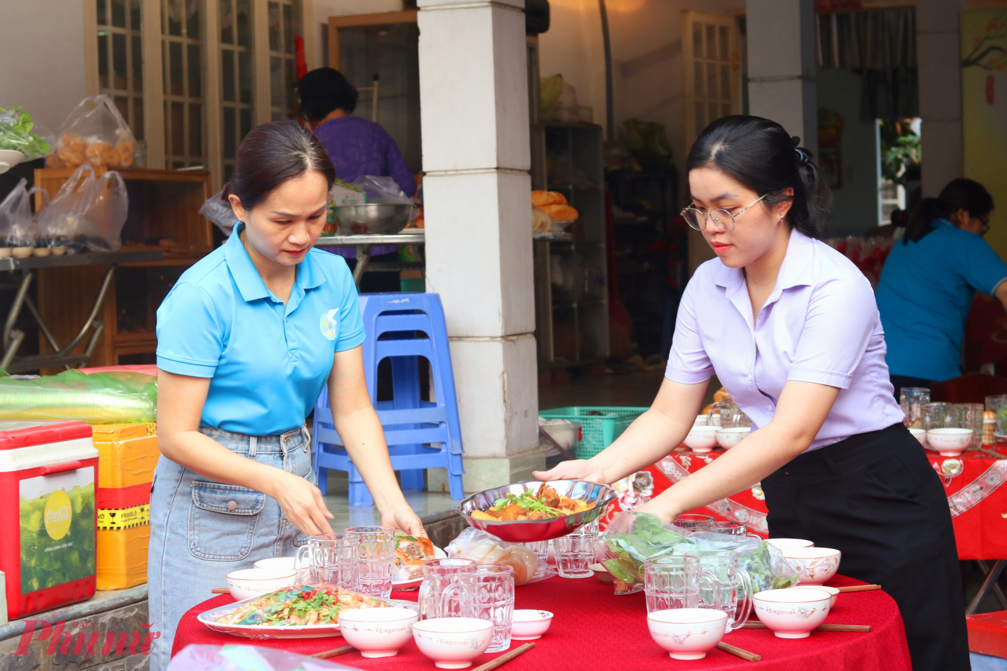 Chị em cán bộ Hội Phụ nữ phường Phước Long chuẩn bị bàn tiệc tất niên đãi người lao động ở khu nhà trọ của gia đình bà Phấn - Ảnh: Mẫn Nhi