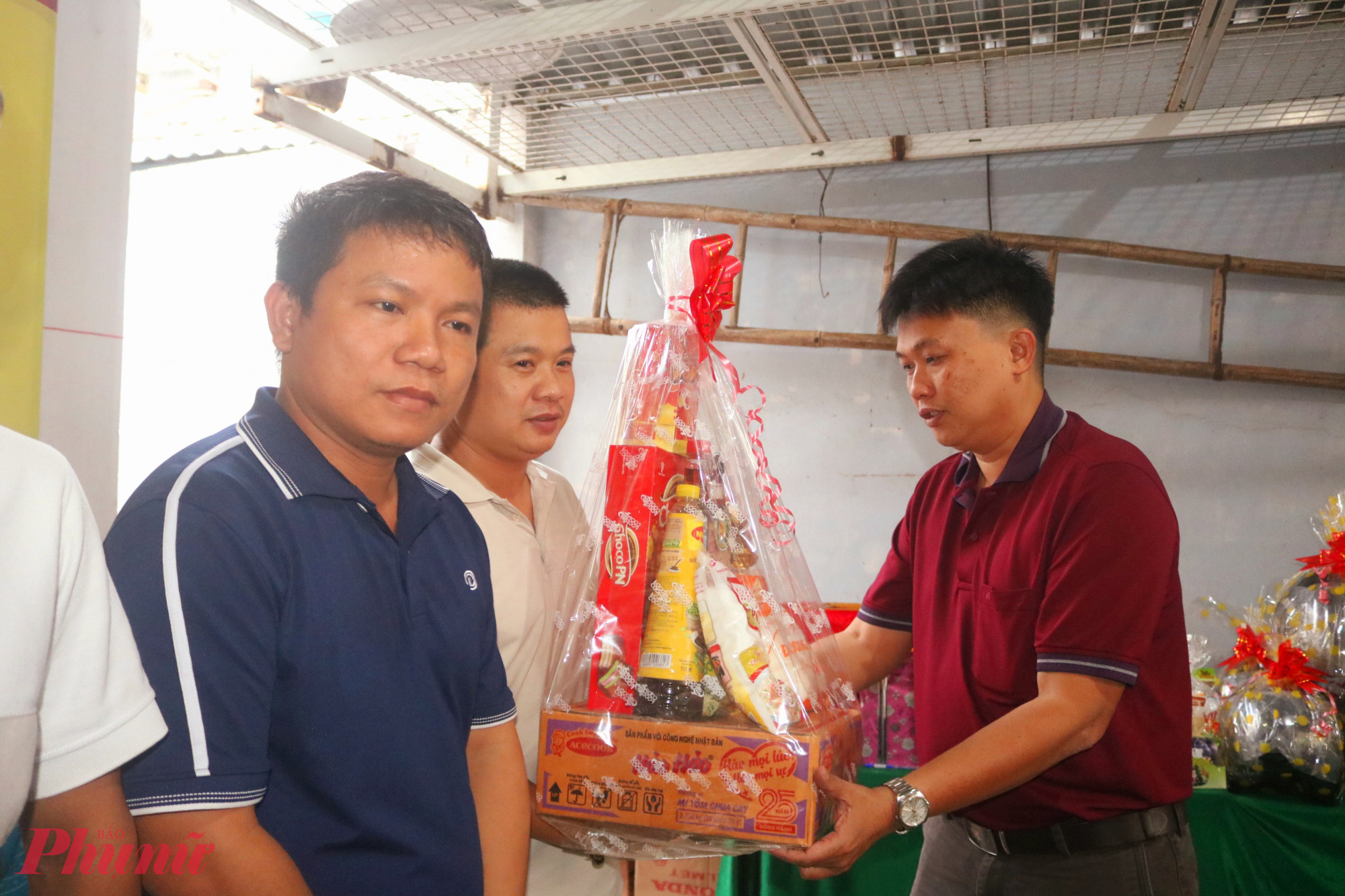 Ông Huỳnh Trần Anh Vũ – Phó trưởng ban Xây dựng Đảng, Đảng ủy phường Phước Long – trao món quà sẻ chia nhân dịp năm mới đến đại diện các phòng trọ - Ảnh: Mẫn Nhi