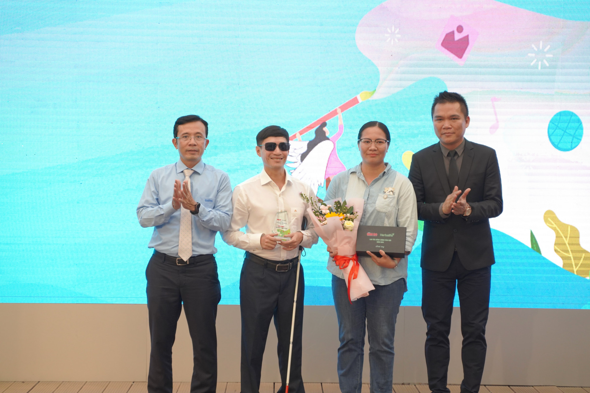 Nhà báo Trần Xuân Toàn - Phó tổng biên tập báo Tuổi Trẻ (bìa trái) và ông Nguyễn Thành Đạt - Giám đốc truyền thông cấp cao Herbalife Việt Nam (bìa phải) trai giải Nhất cho tác giả Hữu Cảnh - Tố Nga - Ảnh: BTC