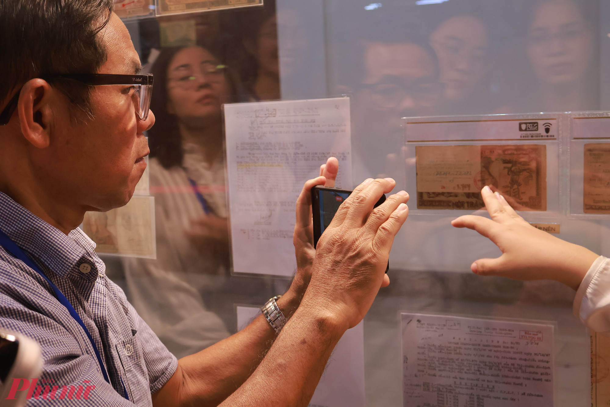 Khách tham quan chăm chú tìm hiểu các bộ sưu tập tiền giấy qua nhiều giai đoạn lịch sử.