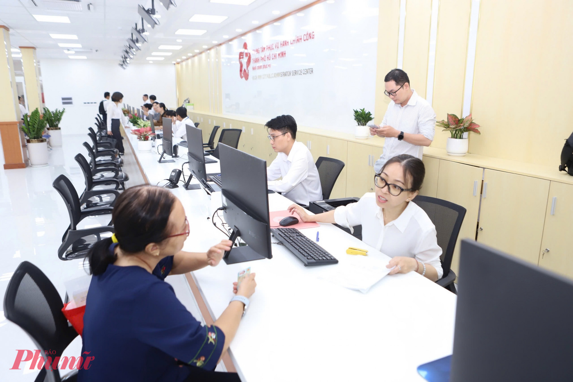 Cán bộ, công chức tận tình hướng dẫn người dân kê khai hồ sơ, tạo thuận lợi cho những trường hợp lần đầu thực hiện thủ tục - Ảnh: Thanh Tâm