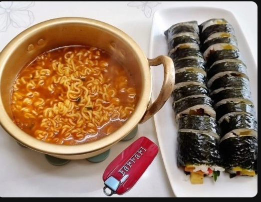 Một hình ảnh chụp được của một bài đăng bình luận Nghèo đói không thể chịu nổi. Hôm nay, tôi lại ăn ramen và kimbap. Khi nào tôi sẽ thoát khỏi cảnh nghèo đói như vậy? với hình ảnh mì ăn liền, kimbap và chìa khóa xe Ferrari bên cạnh bữa ăn (Community Galmuri)