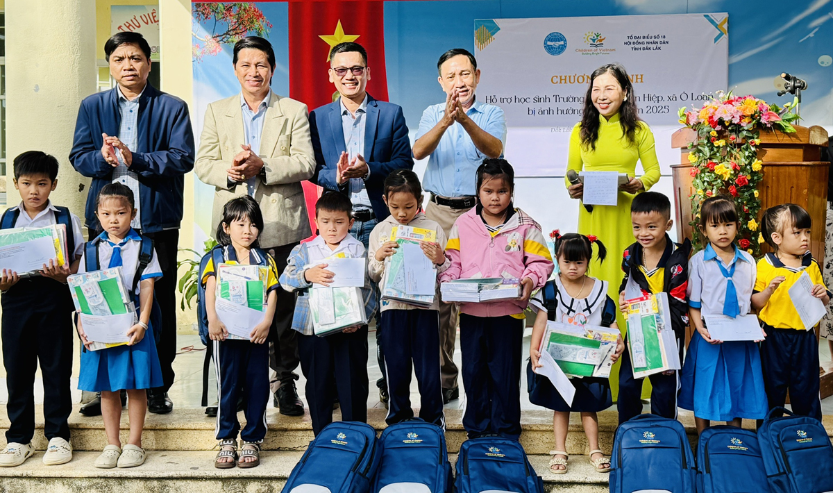 Các đại biểu trao quà cho học sinh Trường Tiểu học An Cư, xã Ô Loan- Ảnh: Thùy Thảo