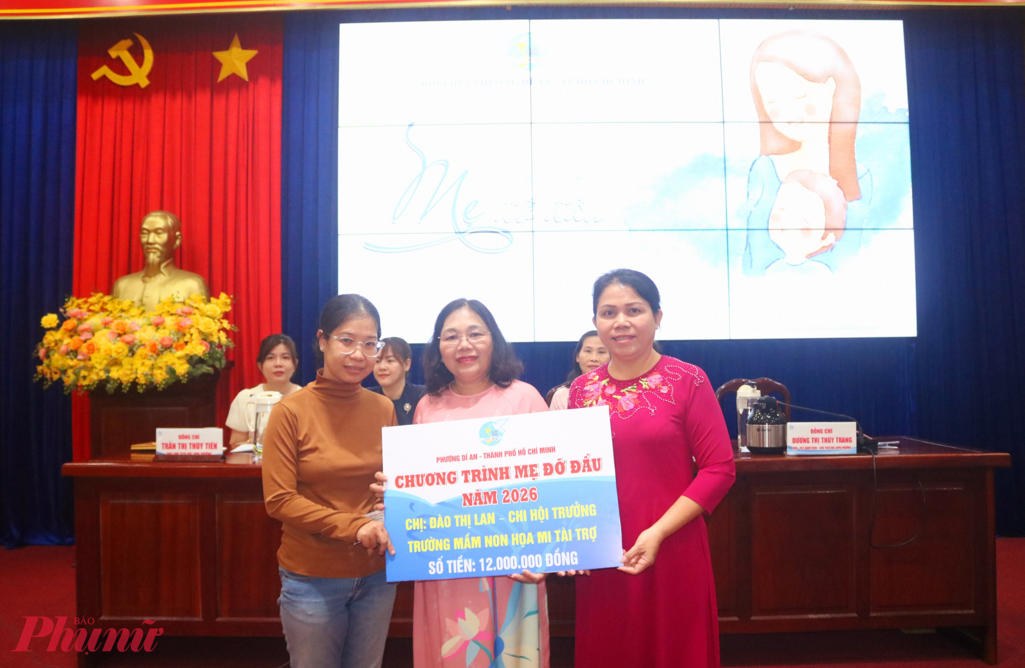 Năm 2026, Trường mầm non Hoạ Mi nhận đỡ đầu chăm lo cho bé Nguyễn Ngọc Hạ Vy (gia đình thuộc diện hộ nghèo, ở khu phố Thống Nhất 2, phường Dĩ An), số tiền 12 triệu đồng/năm. Trong ảnh, bà Dương Thị Thùy Trang – Phó chủ tịch Ủy ban MTTQ Việt Nam phường Dĩ An, Chủ tịch Hội LHPN phường (bìa phải) và cô Đào Thị Lan – Chi hội trưởng Chi hội Phụ nữ Trường mầm non Họa Mi (giữa) – trao bảng tượng trưng kinh phí hỗ trợ cho người thân của bé - Ảnh: Mẫn Nhi