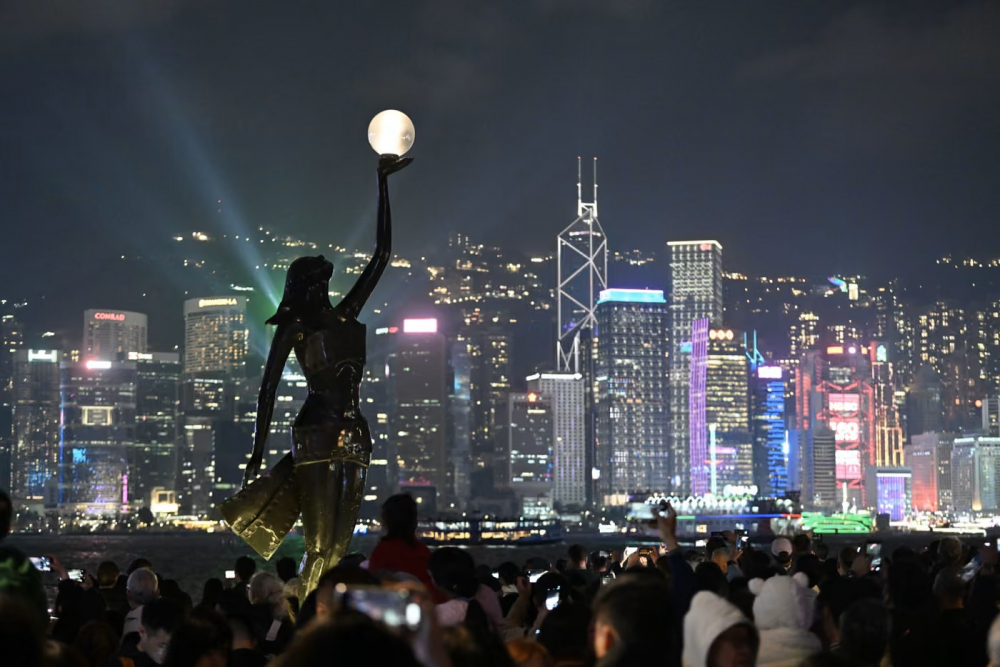 Người dân ngắm nhìn cảnh đêm của Cảng Victoria tại khu Tsim Sha Tsui, Hồng Kông - Ảnh: Kobe Li/Nexpher/ZUMA Press Wire/Shutterstock