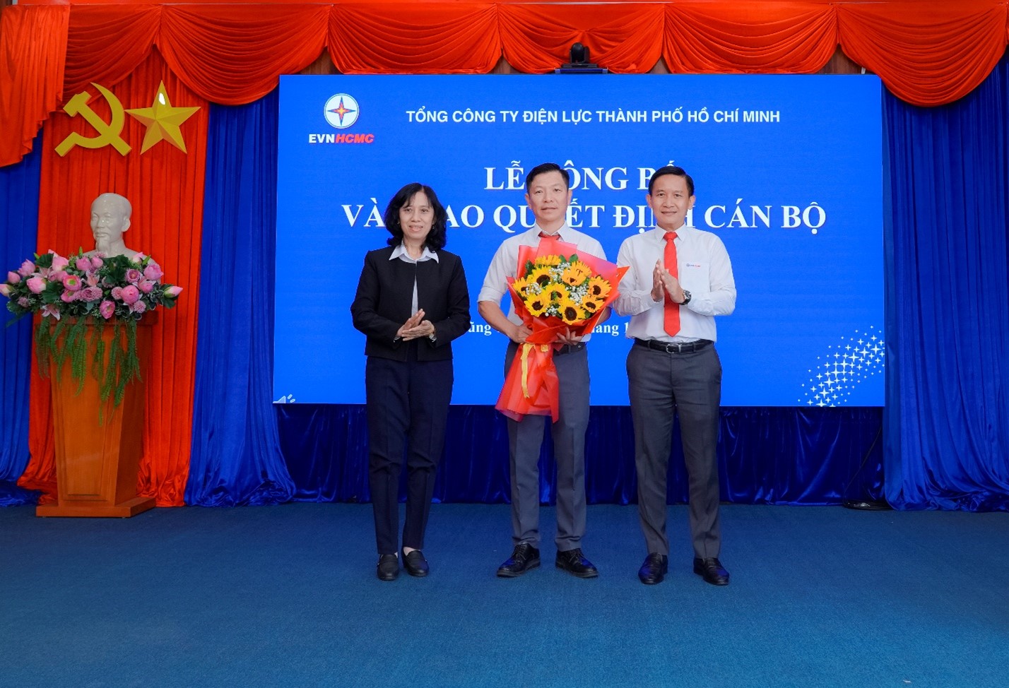 Bà Đỗ Thị Xuân Chi - thành viên HĐTV - và ông Nguyễn Duy Quốc Việt - Phó tổng giám đốc EVNHCMC - trao quyết định và hoa chúc mừng ông Nguyễn Ngọc Tuyến - Ảnh: EVNHCMC