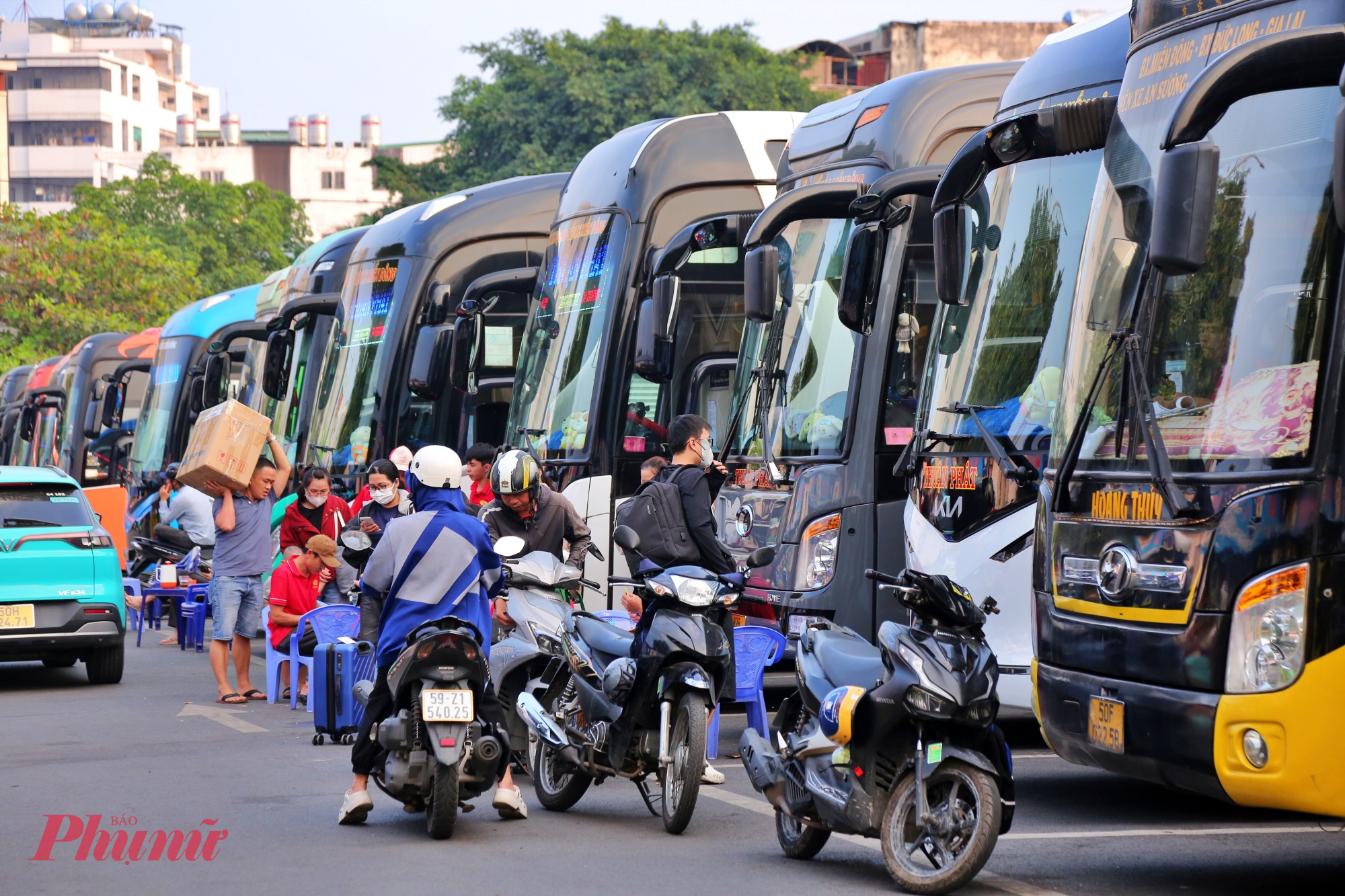 Ngoài bãi xe nhộn nhịp hành khách chờ chất hàng chuẩn bị lên xe về quê.