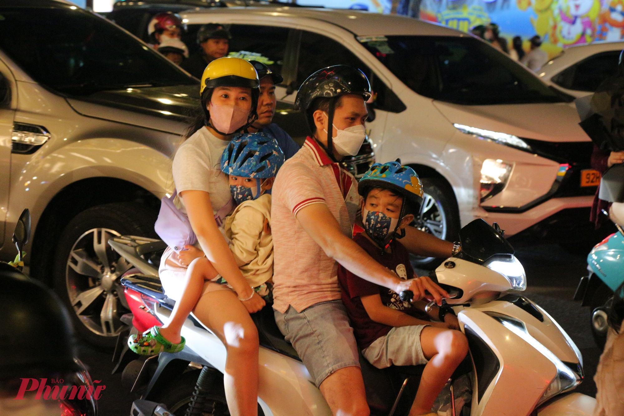Trẻ em mệt mỏi trên xe cùng cha mẹ đi vui chơi xem pháo hoa chào đón năm mới.