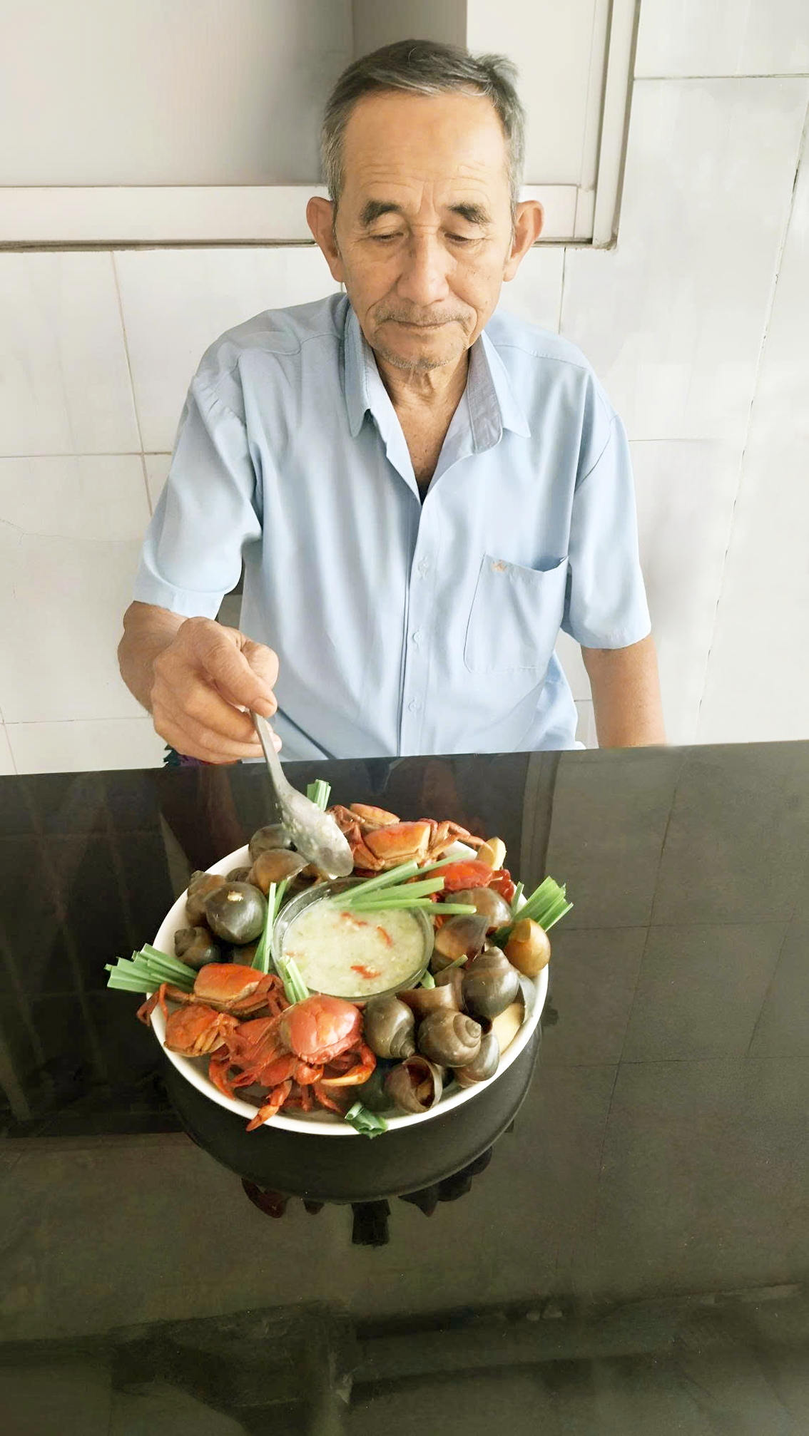 Ông của tác giả và nồi cua ốc chấm nước cơm mẻ - Ảnh do tác giả cung cấp