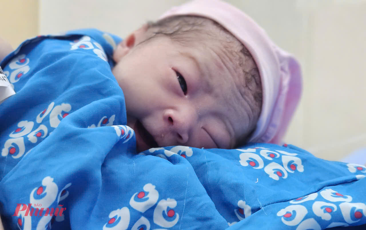 Cảm nhận được hơi ấm của mẹ, bé cười rất tươi đón chào năm mới