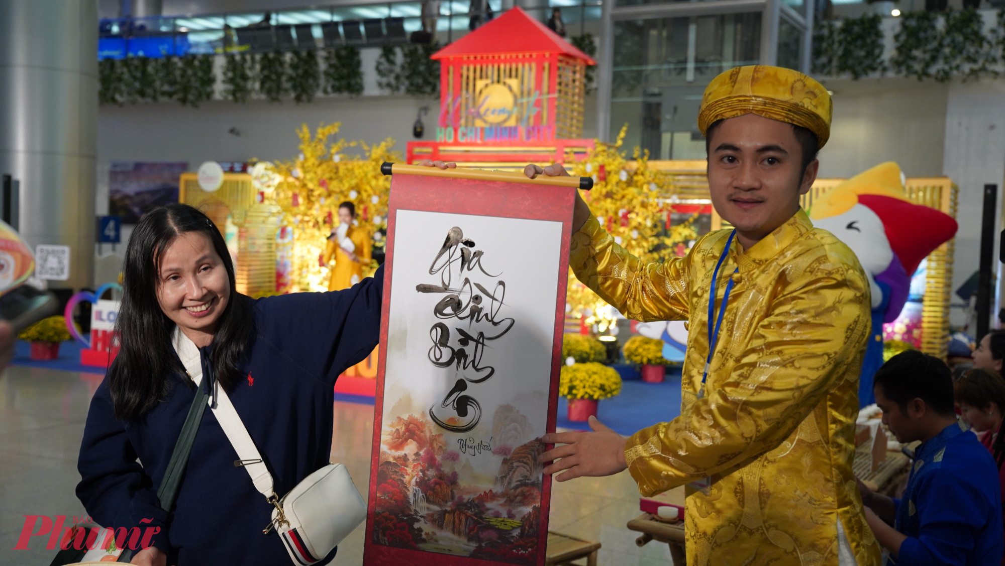 Nữ du khách vui vẻ nhận bức thư pháp từ ông đồ