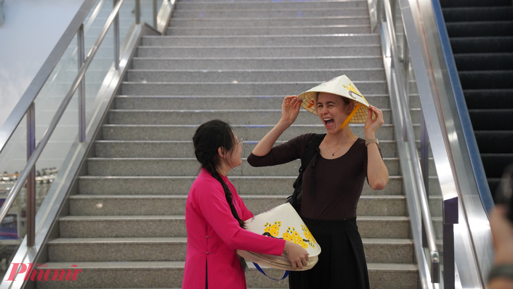 Nữ du khách quốc tế vui mừng khi được tặng nón lá ngay tại sân bay