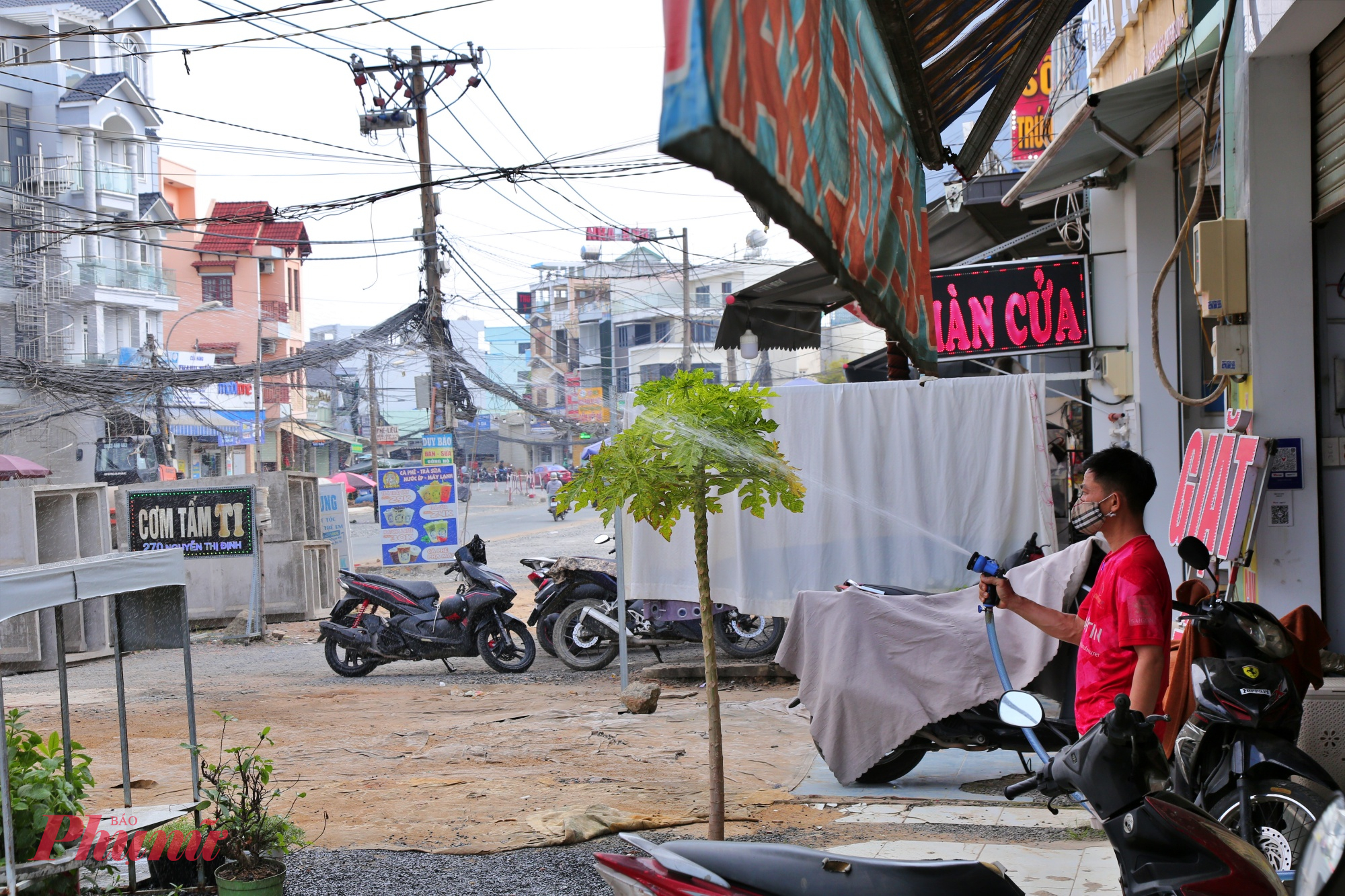 nhiều hộ dân cho biết công trường hiện vẫn còn ngổn ngang đất đá, vật liệu xây dựng do thi công cuốn chiếu theo mặt bằng được bàn giao. Vào những ngày nắng, xe cơ giới ra vào liên tục khiến bụi đất bay mù mịt, phủ kín mặt đường và khu dân cư hai bên. “Có những buổi trưa nắng gắt, bụi bay lên trắng xóa, nhà cửa lúc nào cũng phải đóng kín. Người dân phải tự xịt nước trước cửa nhà vài lần mỗi ngày để giảm bụi,”