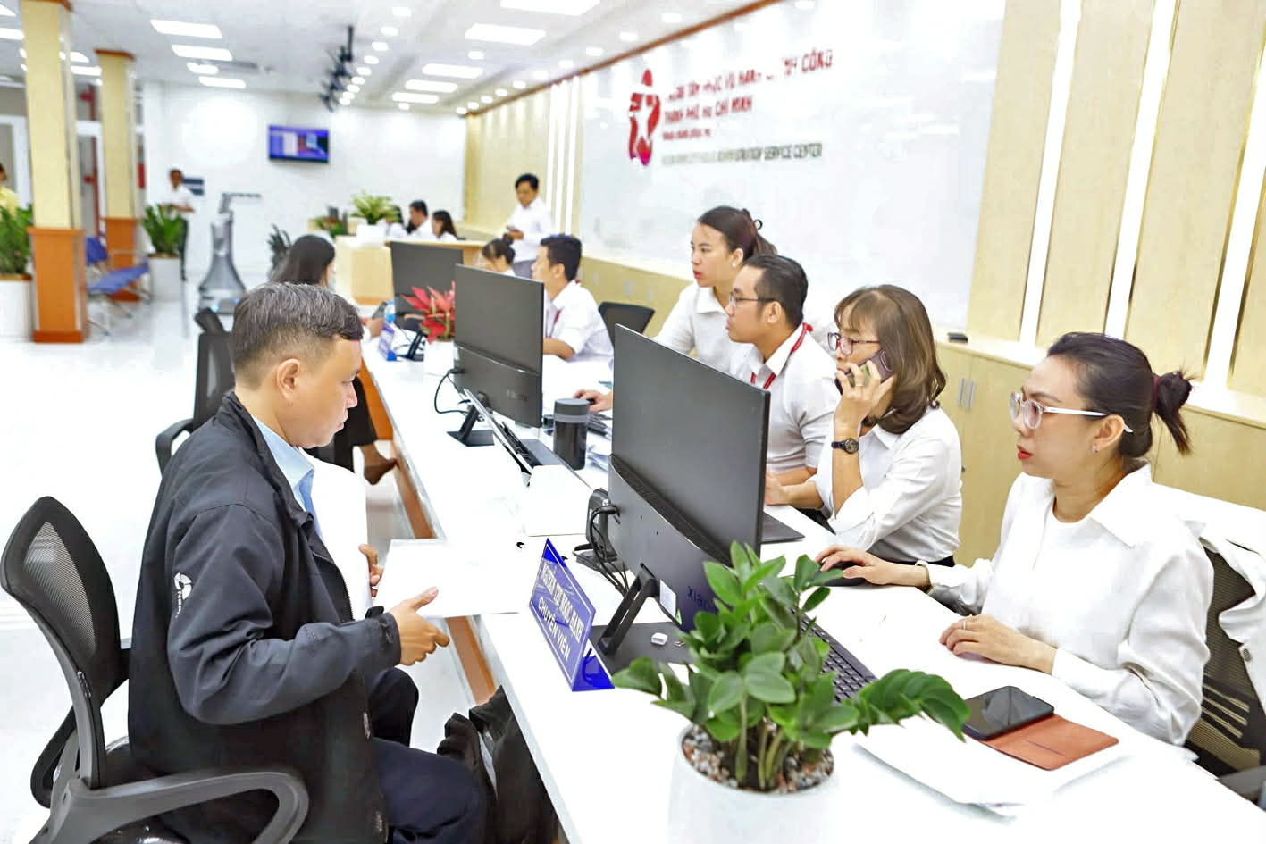 Điểm công dân số - phép thử quan trọng đối với tư duy quản trị hiện đại 2.Cán bộ Trung tâm Phục vụ hành chính công TPHCM giải quyết giấy tờ cho người dân - Thanh Tâm