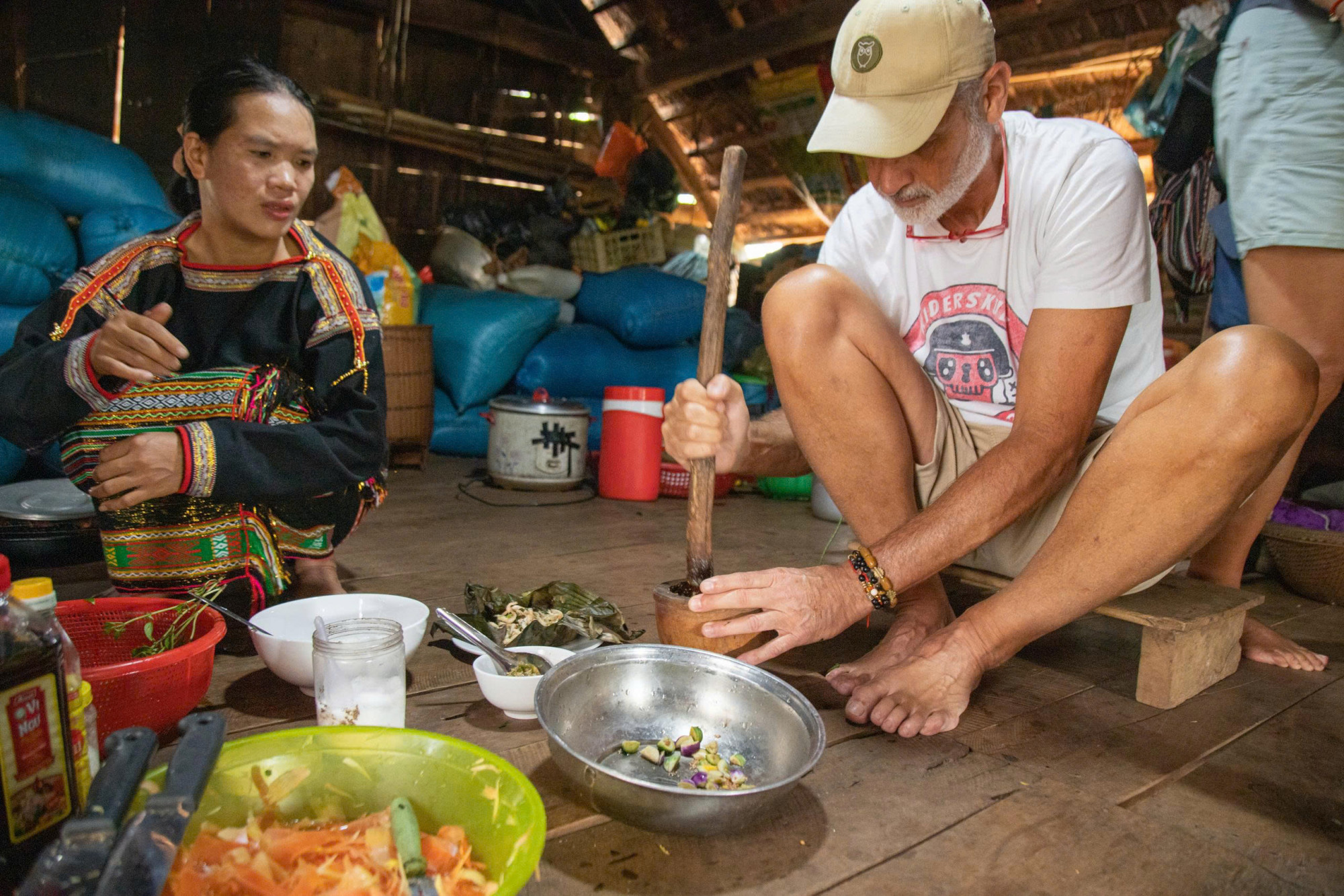 Du khách hào hứng tham gia từng công đoạn, từ giã cà đắng, sơ chế rau rừng đến nấu những món ăn dân dã. 