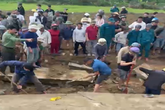 Mọi người nỗ lực đưa các nạn nhân ra khỏi bờ kè - Ảnh: M.N.