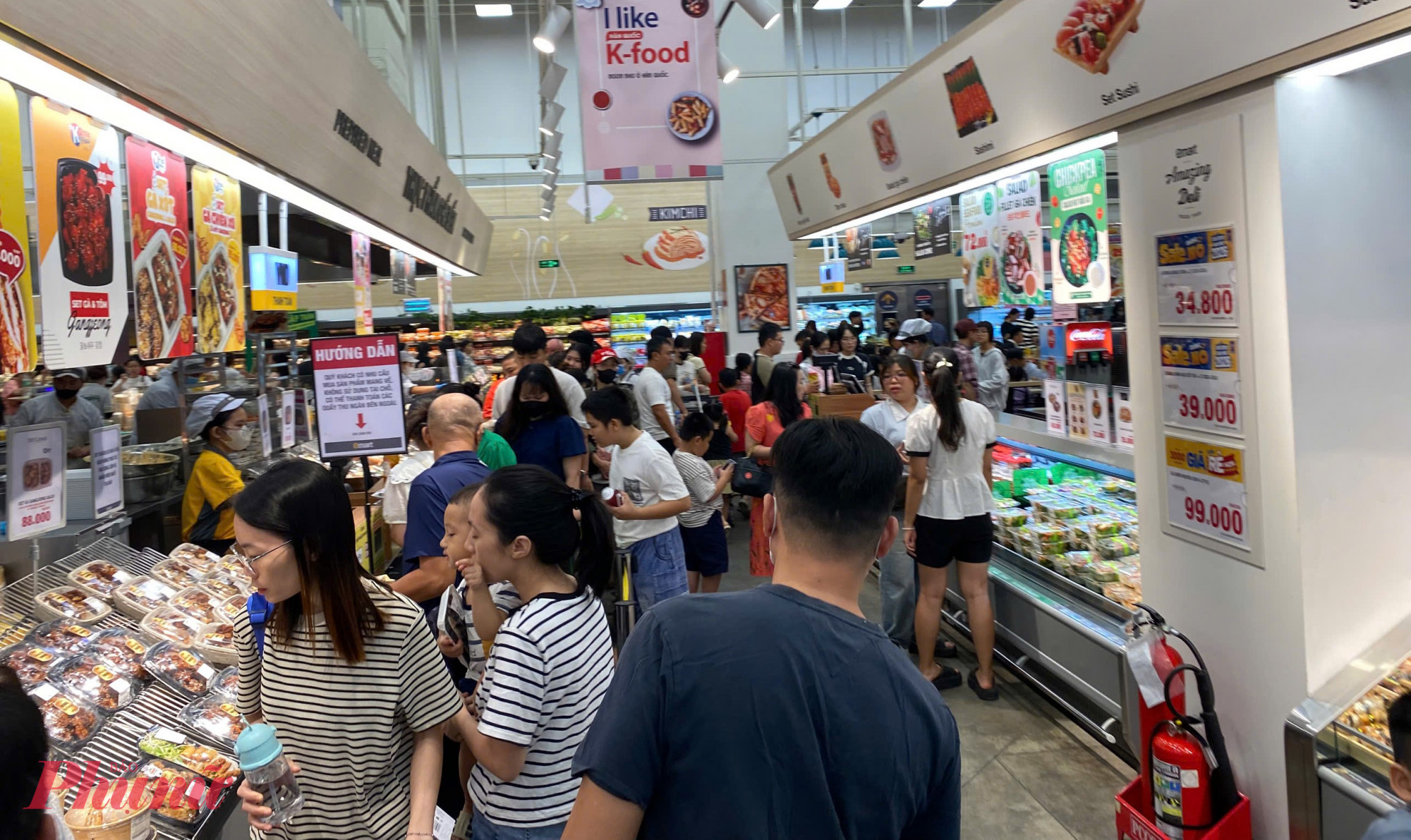 tại Emart Phan Huy Ích. Các lối đi giữa quầy thực phẩm luôn đông người, xe đẩy nối đuôi nhau di chuyển chậm.