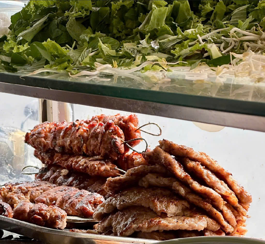 mỗi miếng thịt được quấn quanh một lát mỡ trắng, rồi xỏ xiên đem nướng trên bếp hoa.