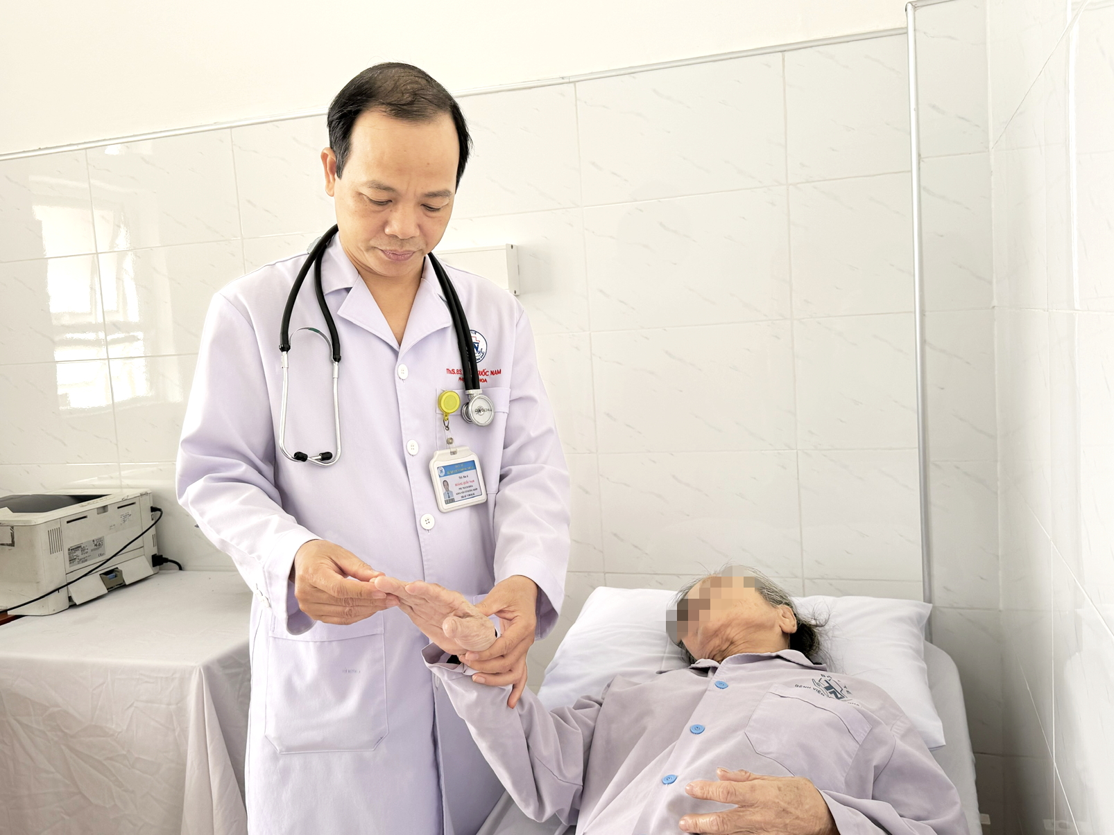 Bác sĩ Hoàng Quốc Nam - Trưởng khoa Nội cơ xương khớp, Bệnh viện Thống Nhất - đang khám cho một cụ bà nhập viện vì thoái hóa khớp