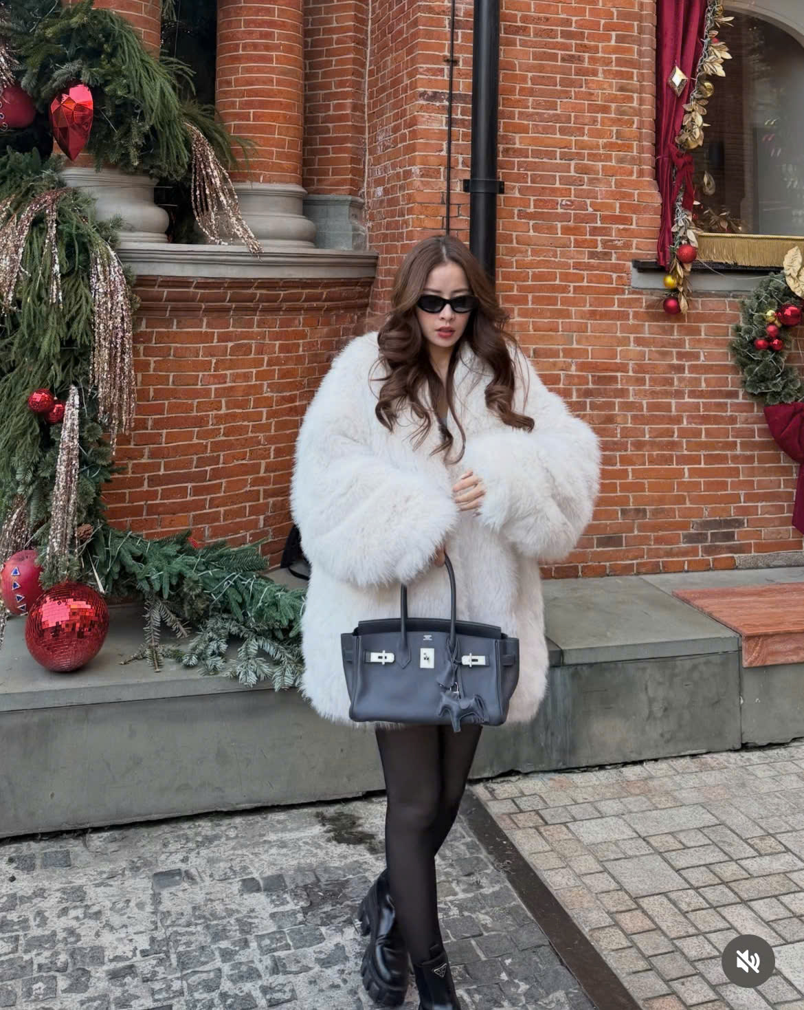 Đến Thượng Hải (Trung Quốc) đón năm mới, Chi Pu xuất hiện với phong cách sang trọng pha nét cổ điển châu Âu, nổi bật giữa không khí lễ hội cuối năm. Nữ ca sĩ diện áo lông trắng dáng rộng tạo cảm giác xa xỉ, mềm mại, kết hợp quần tất đen và boots da đế dày mang đến vẻ thời thượng, cá tính. Phụ kiện túi xách  tối màu dáng cứng cùng kính râm giúp tổng thể thêm phần sang chảnh. Bảng màu trắng đen tương phản vừa tinh tế vừa nổi bật, giúp Chi Pu giữ trọn khí chất thanh lịch nhưng vẫn rất hiện đại.