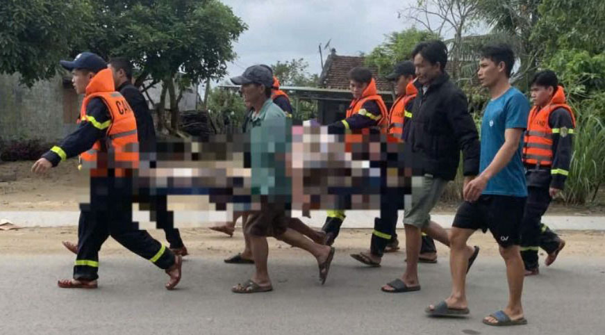 Lực lượng chức năng đưa nạn nhân lên bờ. Ảnh: XC