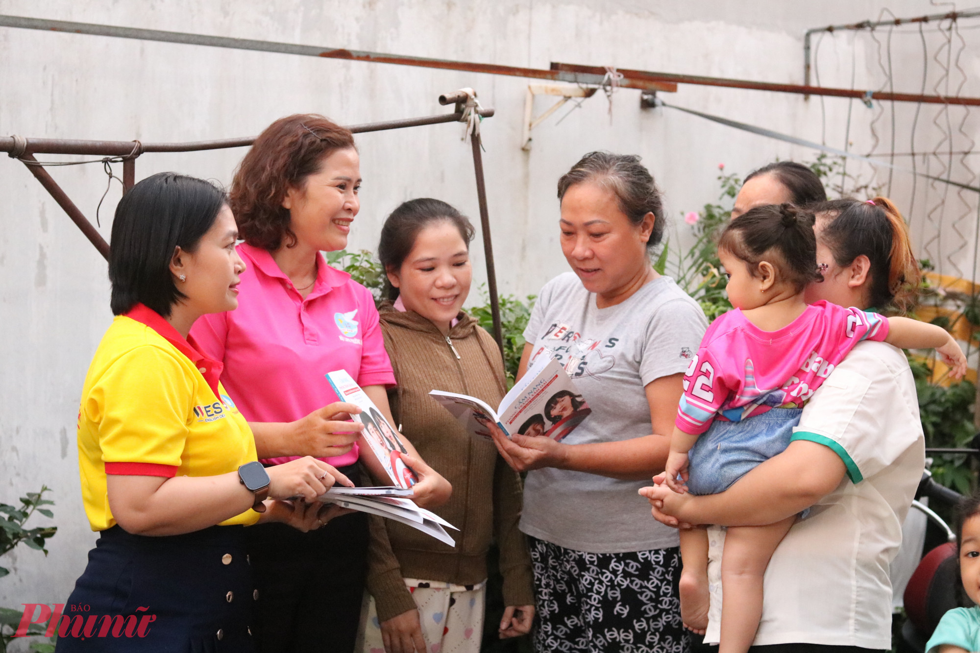 Ban tổ chức trao cẩm nang hướng dẫn kỹ năng phòng chống xâm hại trẻ em cho các chị em trong khu nhà trọ - Ảnh: Thảo Nguyên