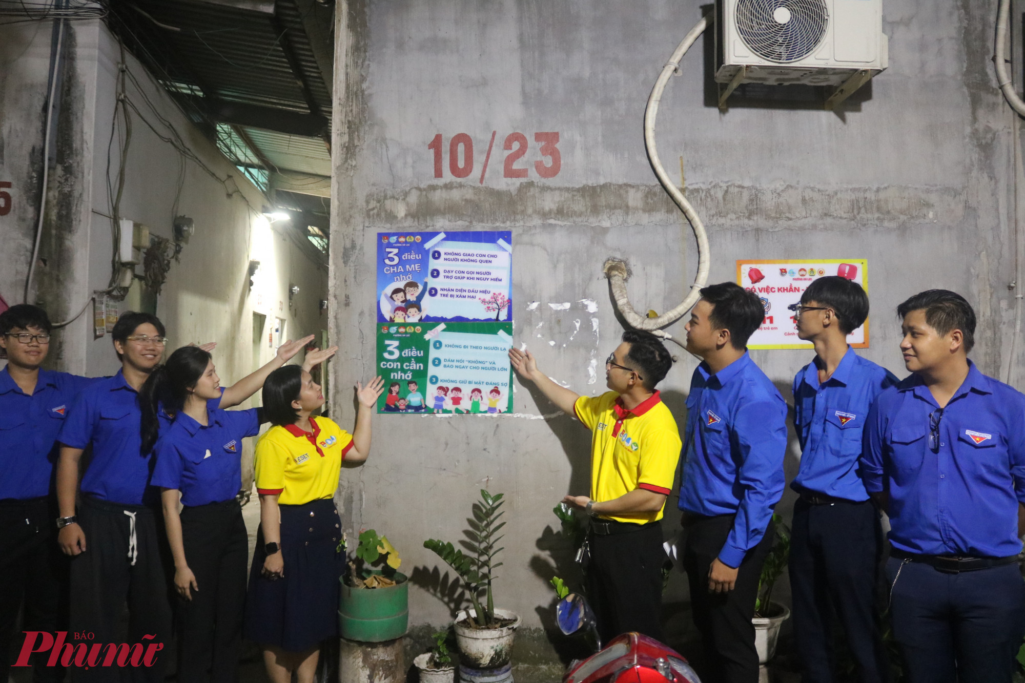 Đại diện các đơn vị cùng chủ nhà trọ gắn bảng thông tin tuyên truyền “Có việc khẩn – gọi ngay!” và các nội dung cha mẹ lẫn trẻ cần nhớ để phòng tránh xâm hại- Ảnh: Thảo Nguyên