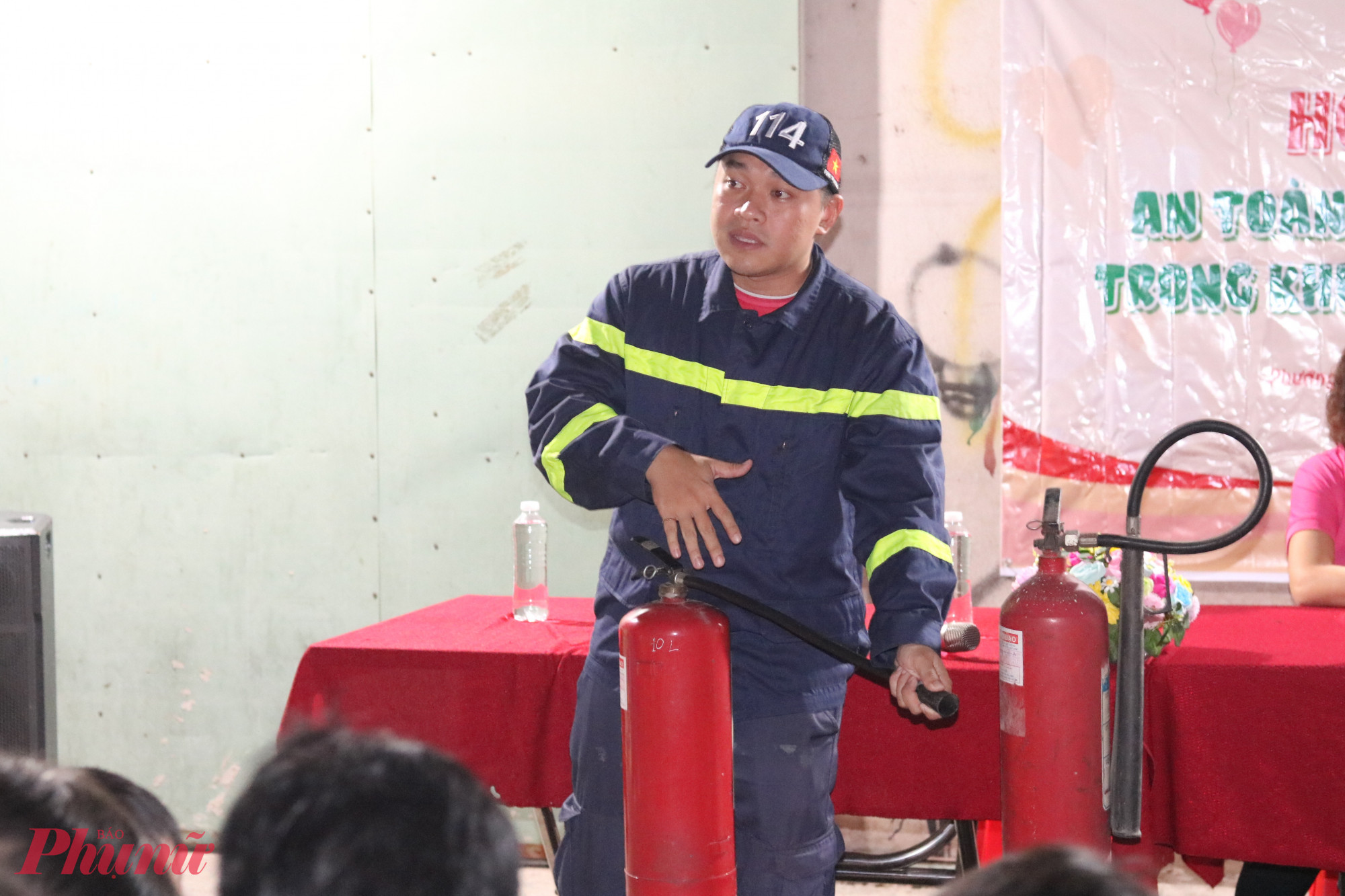 Đại úy Huỳnh Quang Khải – Cán bộ Đội chữa cháy và cứu nạn cứu hộ khu vực 9 -  hướng dẫn anh chị em ở khu nhà trọ cách sử dụng bình chữa cháy cầm tay - Ảnh: Thảo Nguyên