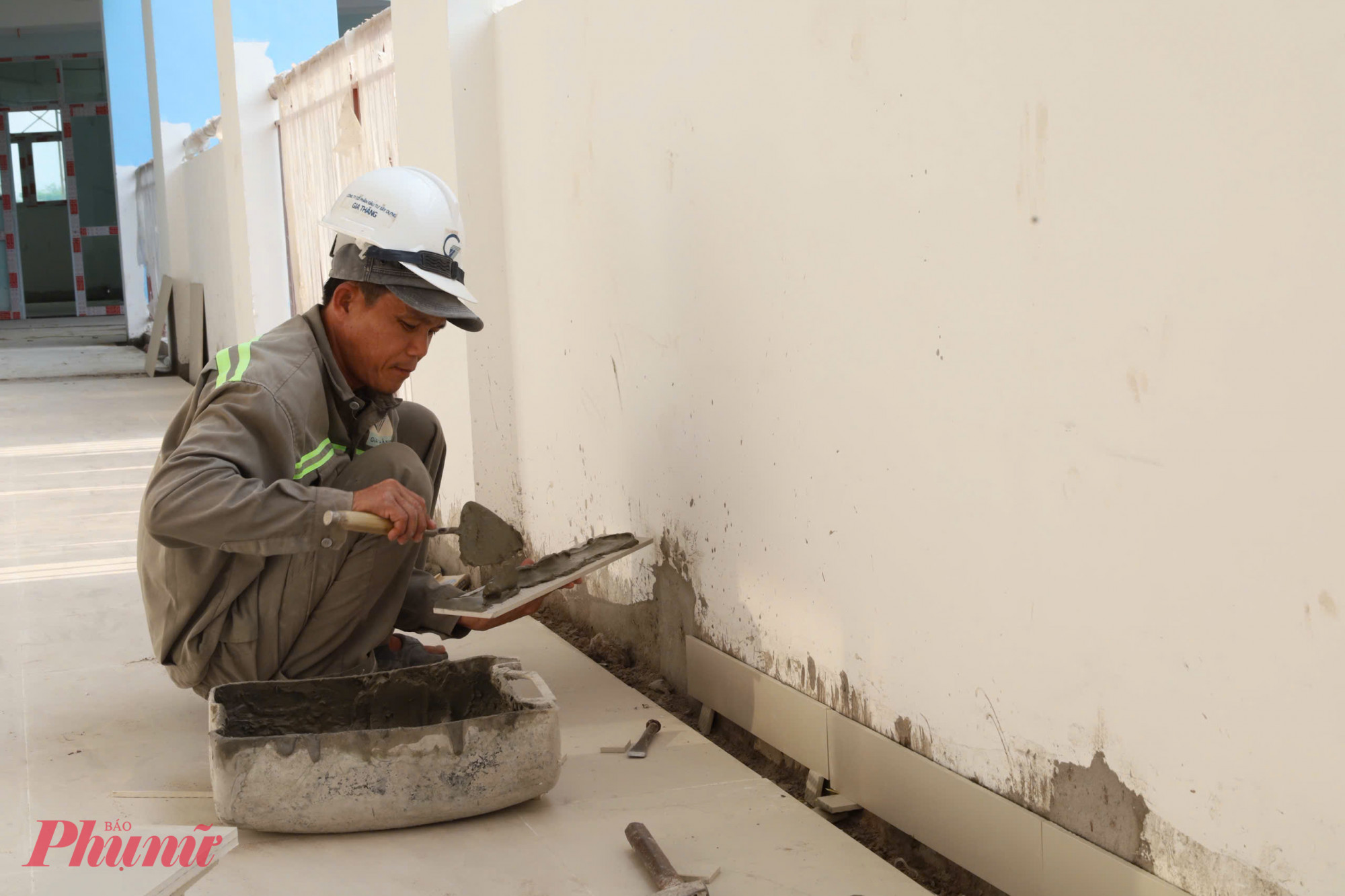 Công nhân thực hiện công đoạn ốp tường ngoài hành lang.