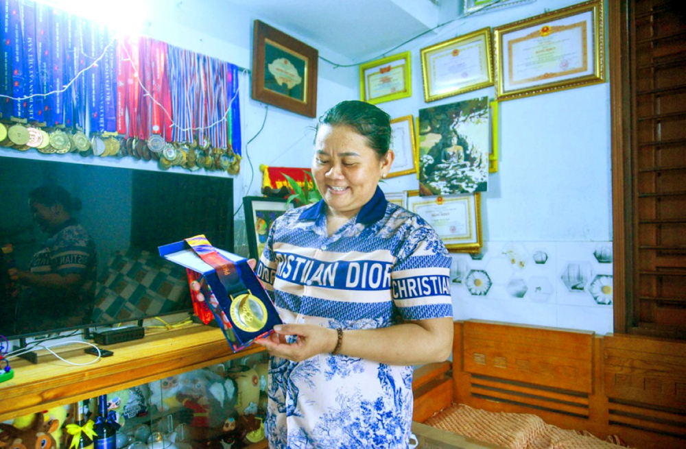 Bà Đặng Thị Huệ khoe những tấm huy chương vàng của các con