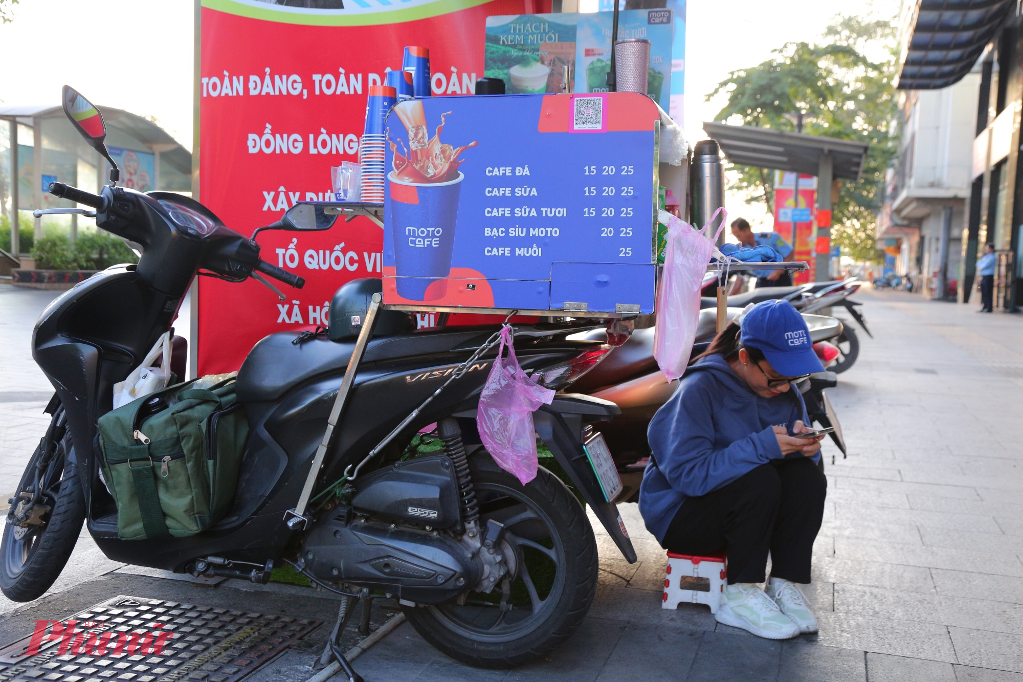 Tại khu vực đường Nguyễn Huệ, giữa không gian rộng mở ven sông, gió lạnh càng thổi mạnh hơn. Chị Thanh Trúc (26 tuổi), bán cà phê mang đi, phải ngồi co ro trong thùng hàng để tránh gió. “Em ra đây từ sớm để bán cà phê nhưng phải ngồi nép lại cho đỡ lạnh. Hôm nay em cảm nhận lạnh hơn mọi khi, nhưng cũng thấy khá thích thú vì cảm giác như đang ở Đà Lạt,” chị Trúc chia sẻ.