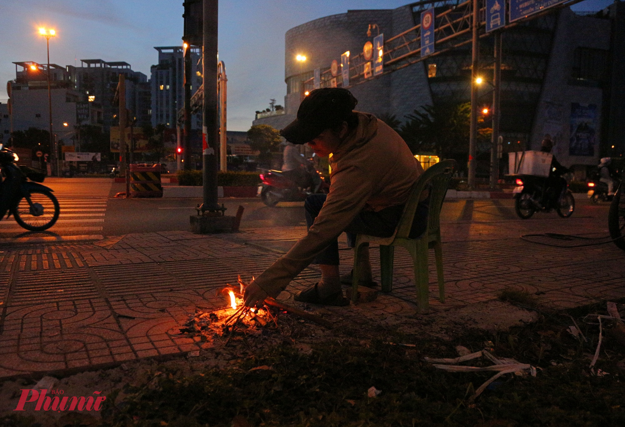 Từ khoảng 5h30 giờ sáng, cái lạnh thấm nhanh qua từng làn gió. Trên vỉa hè đường Phạm Văn Đồng (phường Hiệp Bình), chị Trâm (44 tuổi) vừa quạt nhẹ đống lửa, vừa xoa tay cho đỡ buốt.
