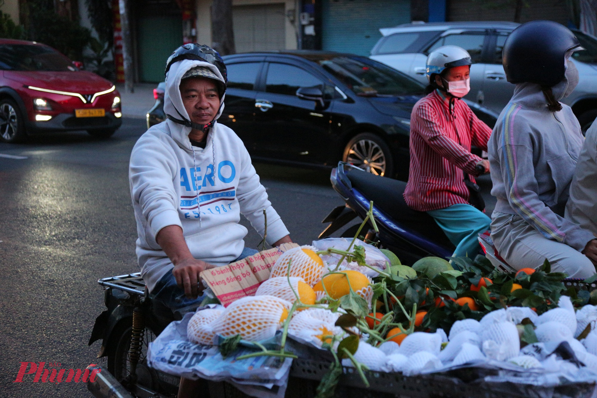 Thường ngày, người đàn ông này dậy sớm chở xe trái cây đi bán nhưng hôm nay cảm nhận được không khí lạnh để buốt giá nên anh phải mặc áo trùm cổ.
