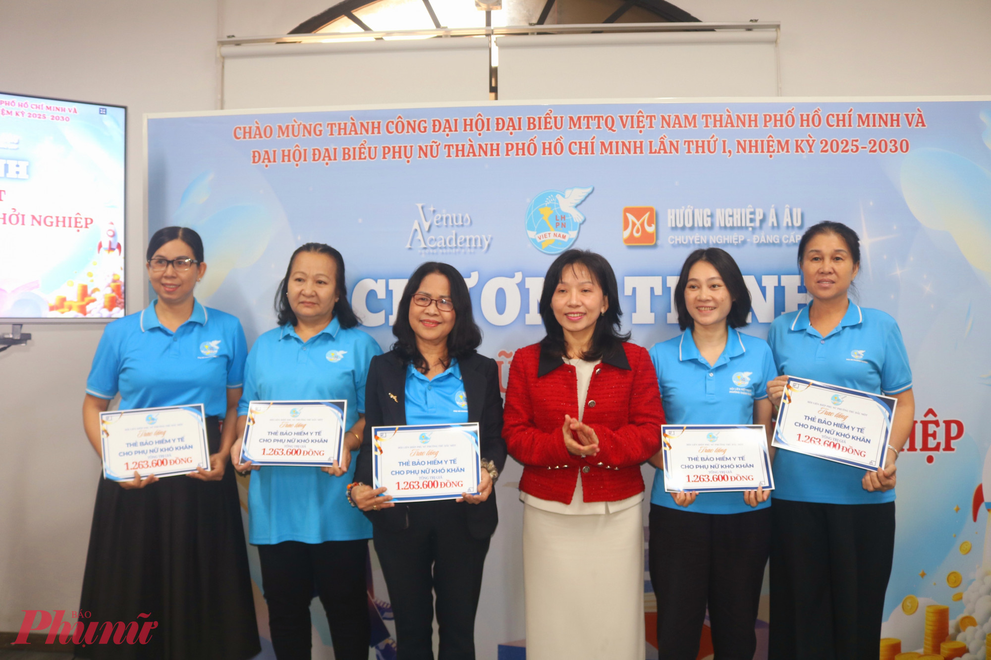 Bà Huỳnh Thị Thúy Phương – Phó chủ tịch Hội LHPN TPHCM (thứ 3, từ phải qua)– trao bảng tượng trưng thẻ bảo hiểm y tế cho các chị chi hội trưởng phụ nữ phường Thủ Dầu Một - Ảnh: Mẫn Nhi 