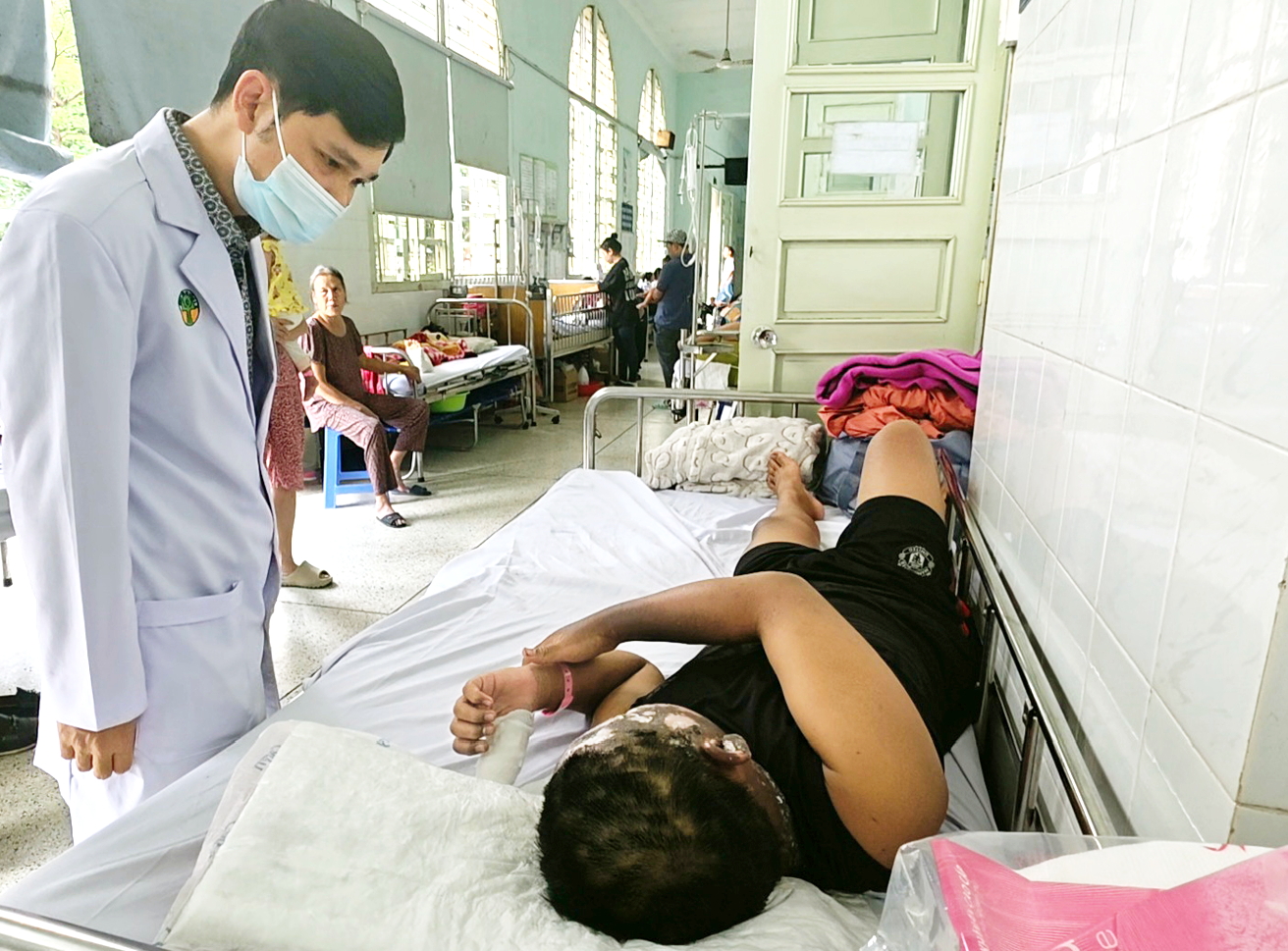 Bác sĩ Ngô Hồng Phúc - Trưởng khoa Bỏng - Chỉnh trực, Bệnh viện Nhi Đồng 2 - thăm khám cho em P. bị tai nạn pháo nổ