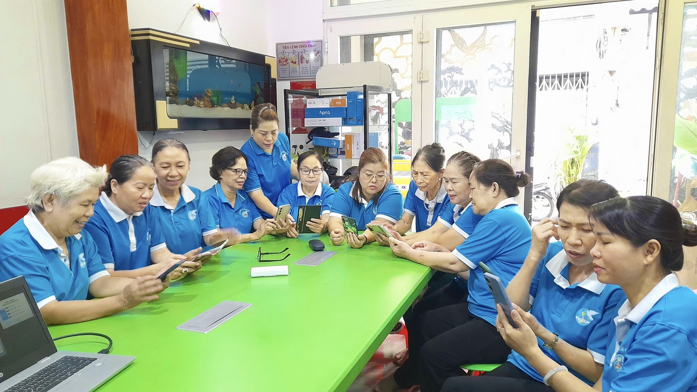 Chị Hồ Ngọc Thùy Trang (đứng) hướng dẫn hội viên phụ nữ sử dụng các ứng dụng công nghệ