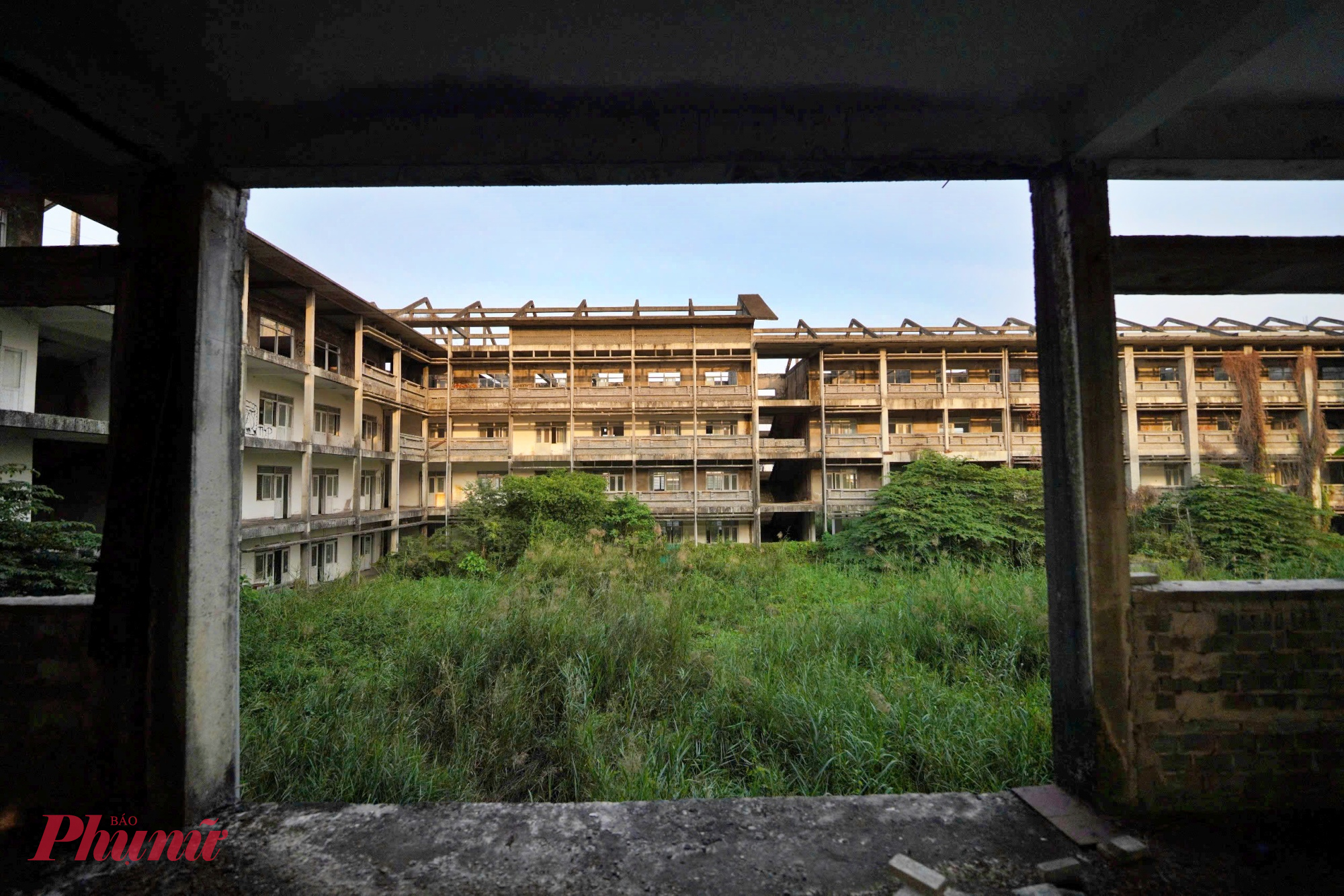 ba khối trường học đã hoàn thiện phần thô, khung bê tông cốt thép kiên cố, nhưng bên trong trống trơn, cỏ dại mọc um tùm, nhiều hạng mục xuống cấp theo thời gian. 
