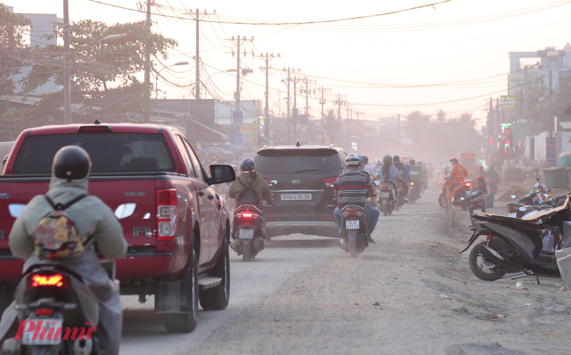 Vào giờ cao điểm, ô tô lưu thông trên đường này nhiều hơn nên bụi càng bay trắng xóa.