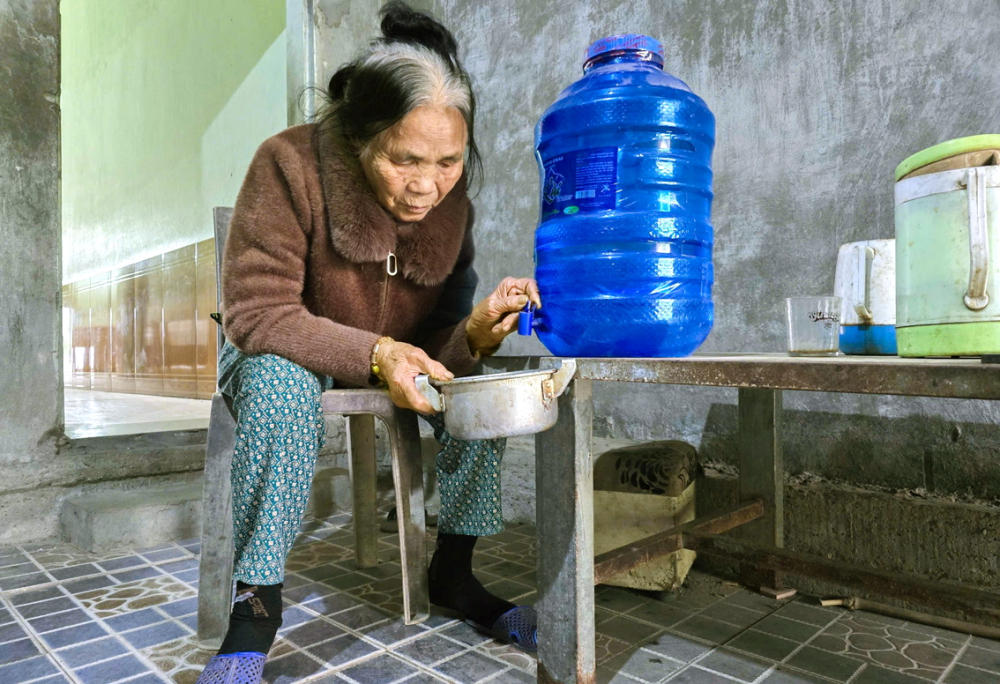 Nước giếng bị ô nhiễm, bà Nguyễn Thị Cầu phải mua nước bình về nấu ăn hằng ngày