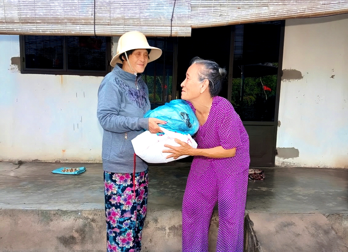 Bà Hồ Thị Kim Oanh (bìa trái) đến tận nhà trao quà cho phụ nữ khó khăn