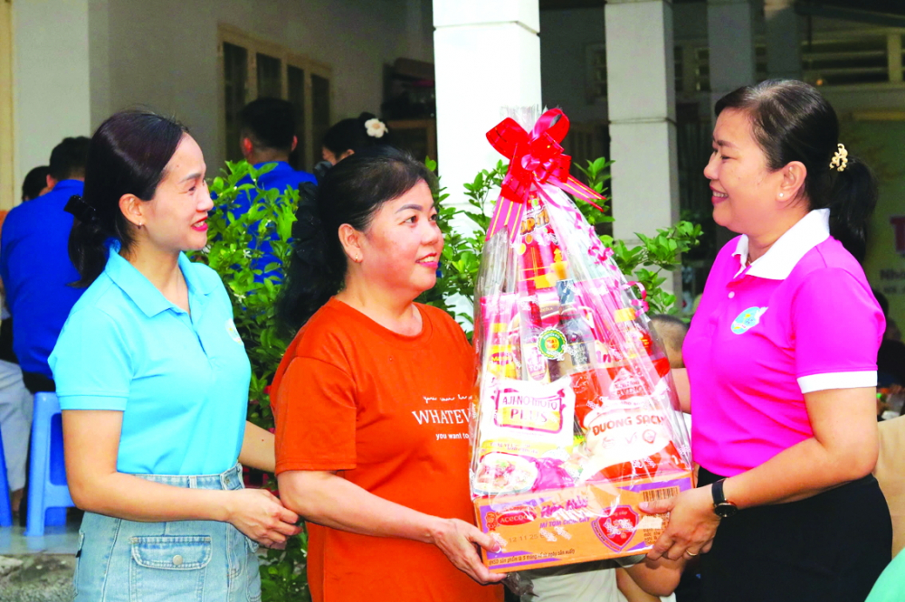 Bà Nguyễn Thị Thanh Xuân (bìa phải) - Phó chủ tịch Ủy ban MTTQ Việt Nam phường, Chủ tịch Hội LHPN phường Phước Long và bà Phạm Ngọc Hảo Vy (bìa trái) - Phó chủ tịch Hội LHPN phường - trao quà tết cho nữ công nhân trên địa bàn ẢNH: MẪN NHI