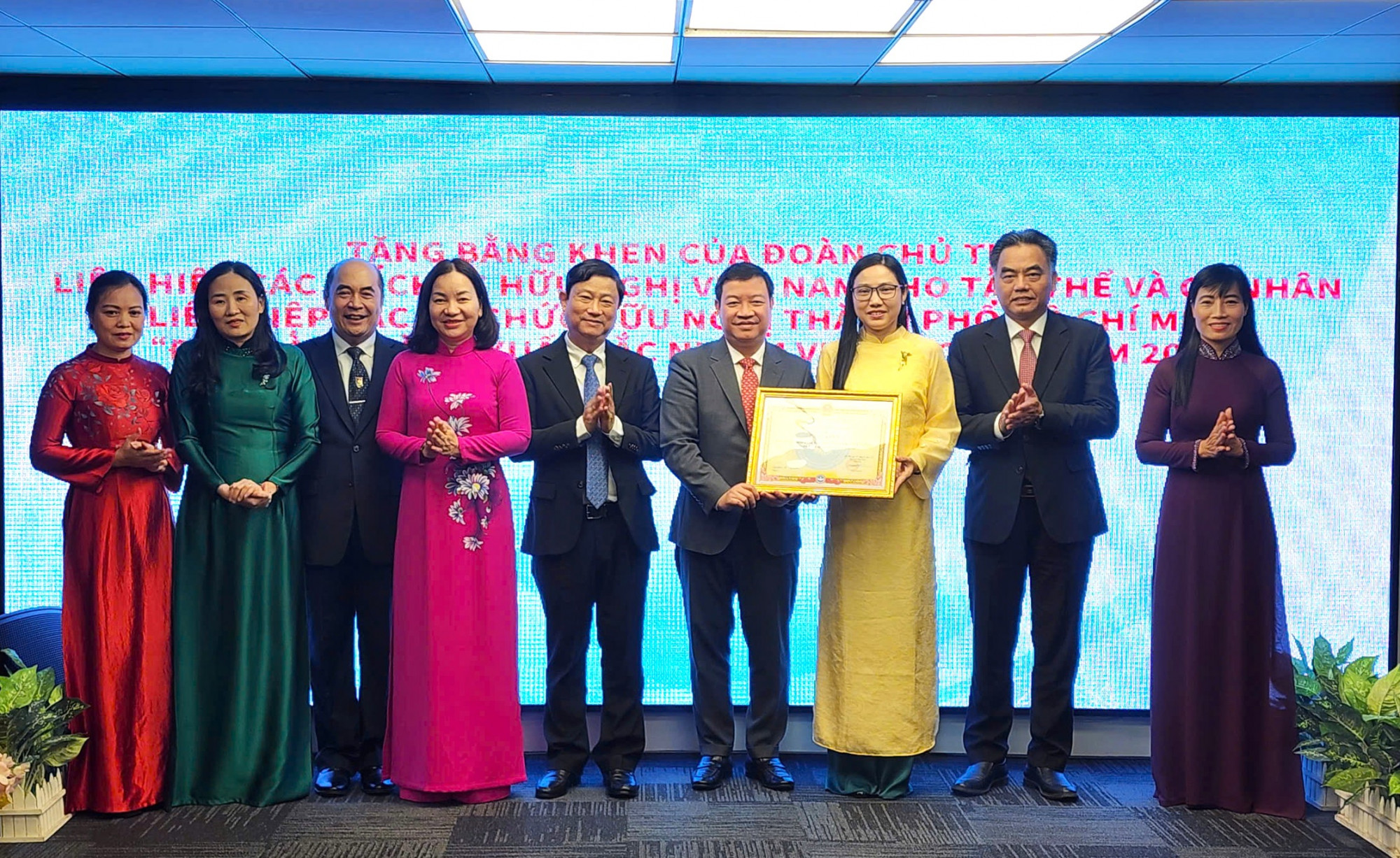 Ông Nguyễn Ngọc Hùng - Phó Chủ tịch Liên hiệp các tổ chức hữu nghị Việt Nam (thứ 6 từ trái sang) trao tặng bằng khen đến Liên hiệp các tổ chức hữu nghị TPHCM (HUFO) 