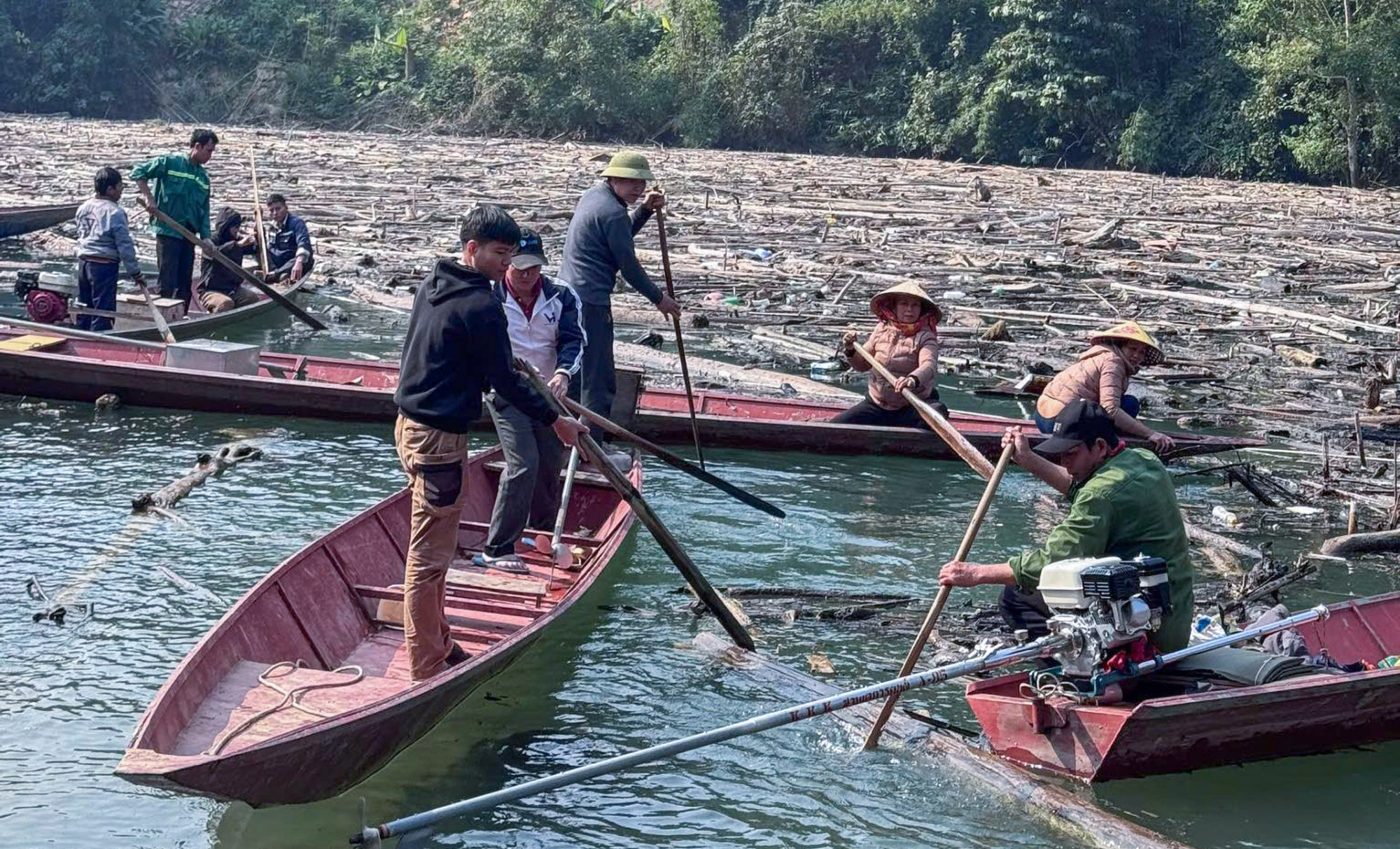 Hàng trăm người được huy động dọn dẹp rác, mở đường thủy để đi lại - Ảnh: Lô Giáo