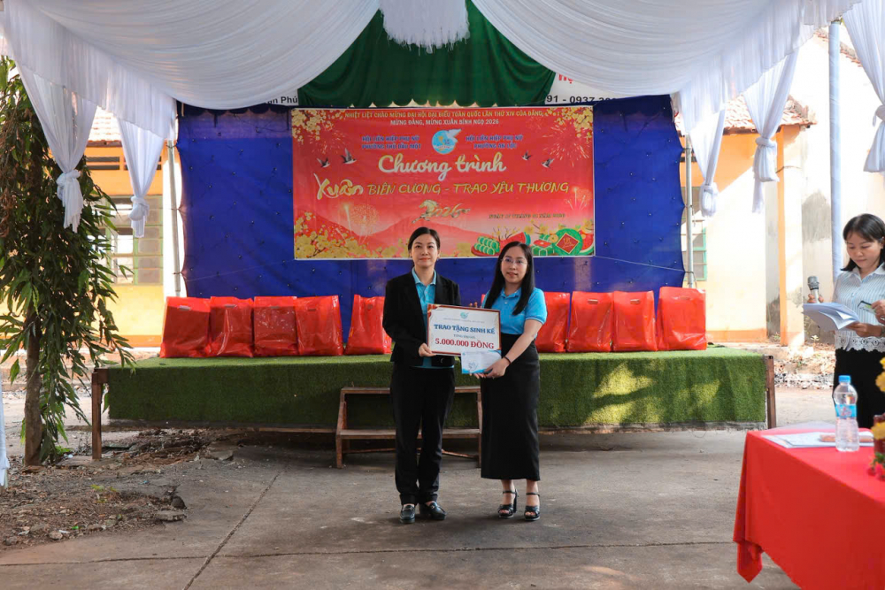 Bà Đinh Thị Ngọc Cẩm – Phó chủ tịch Ủy ban MTTQ Việt Nam phường An Lộc, Chủ tịch Hội LHPN phường (bìa trái) nhận bảng tượng trưng kinh phí mua phương tiện sinh kế cho hội viên do bà Lê Thị Thúy Hà - Phó chủ tịch Ủy ban MTTQ Việt Nam phường Thủ Dầu Một, Chủ tịch Hội LHPN phường trao - Ảnh: Hội LHPN phường Thủ Dầu Một