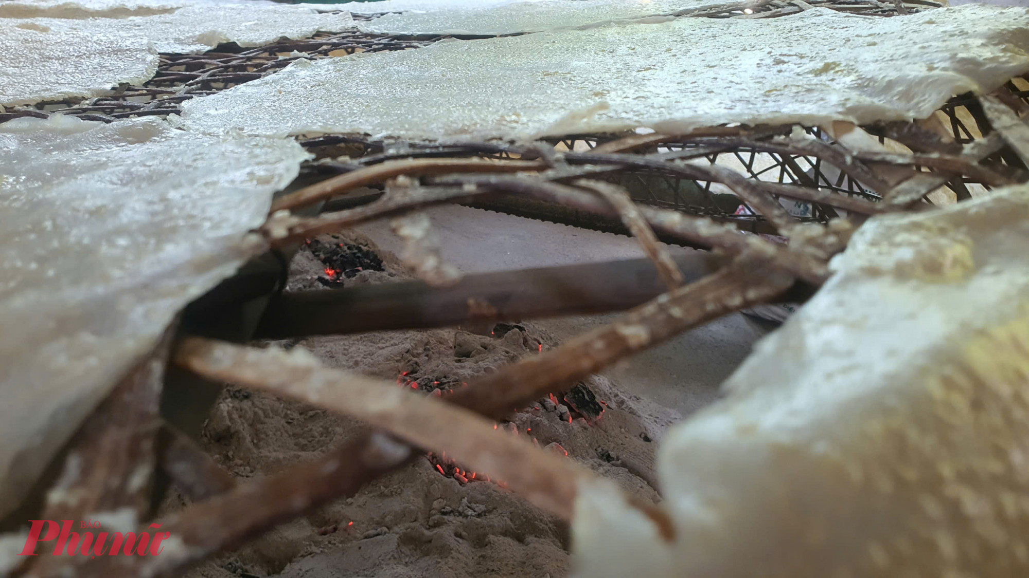 Bà Hòa giải thích, thời tiết miền Trung những ngày cận Tết thường mưa phùn hoặc thiếu nắng, việc sấy bằng than giúp bánh khô đều, giữ được độ giòn tan và bảo quản được rất lâu mà không bị mốc. Người thợ phải ngồi bên lò lửa nóng hừng hực suốt 3-4 tiếng đồng hồ, liên tục trở bánh để đảm bảo chúng không bị cháy sạm hay cong vênh.