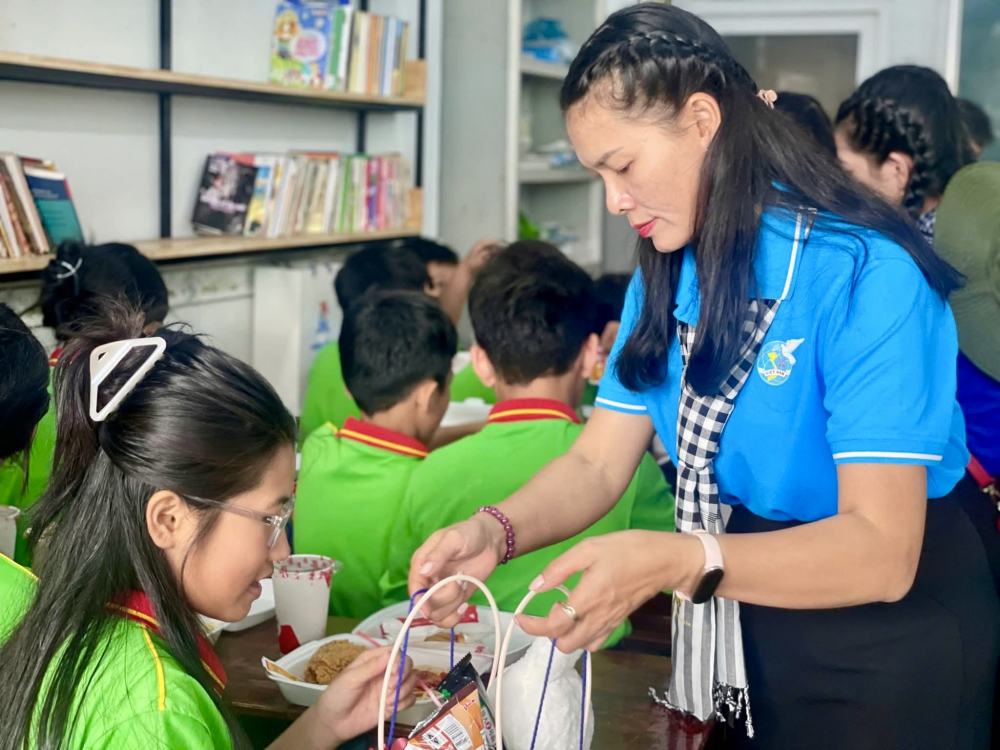 Bà Vi Thị Tâm Lai – Chủ tịch Hội LHPN phường Phú Lợi trao quà tết cho các em học sinh